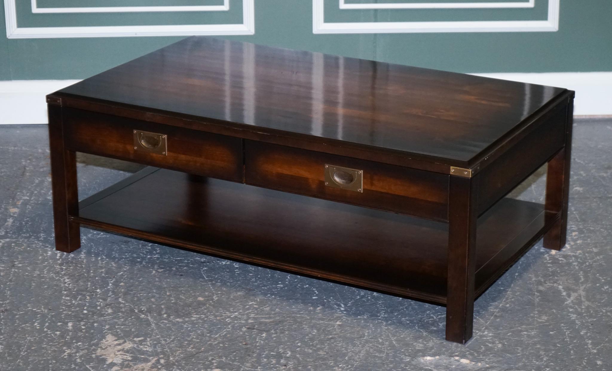 We are so excited to present to you this stunning vintage military campaign mahogany & brass coffee table.

The table has been retailed by John Lewis, you can see the plaque in one of the drawers.
Very good-looking piece with 2 drawers which work