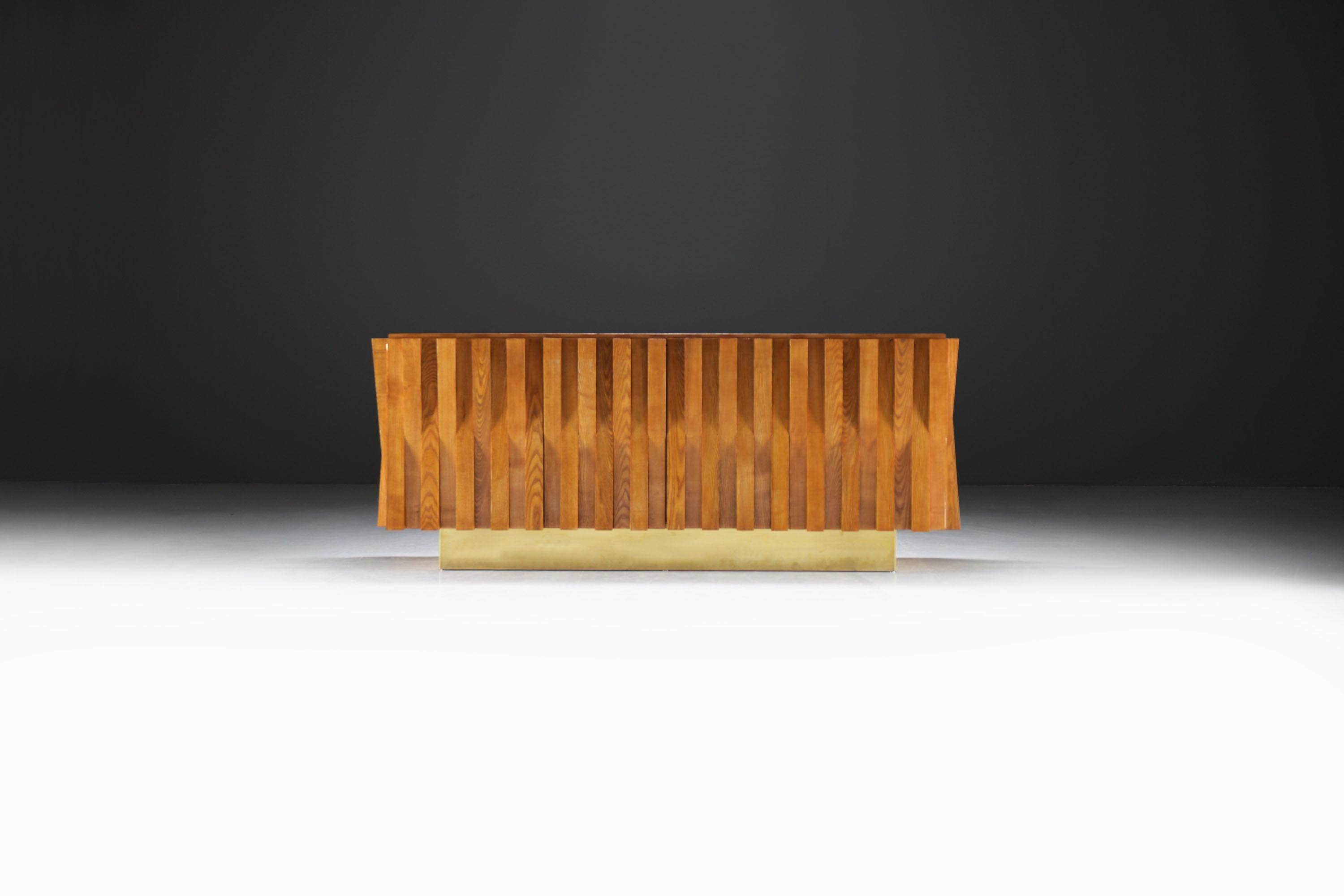 Ce superbe buffet en bois du milieu du siècle est doté d'un design unique de lattes verticales sur la façade, ce qui lui confère un aspect chaleureux et accueillant avec un grain naturel qui ajoute de la texture et de la profondeur. Les portes