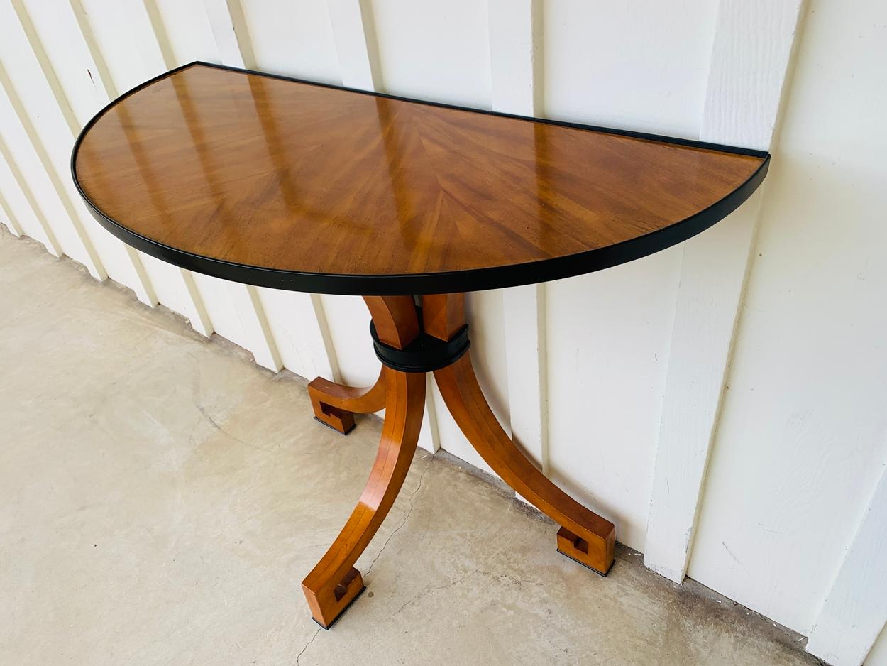Stunning Art Deco style wall console feuturing a sunburst wooden top and Greek key legs.

The piece has a demilune shape, black wooden accents ad is in very good condition.

Measurements: 45 inches wide x 20 inches deep x 36 inches high.