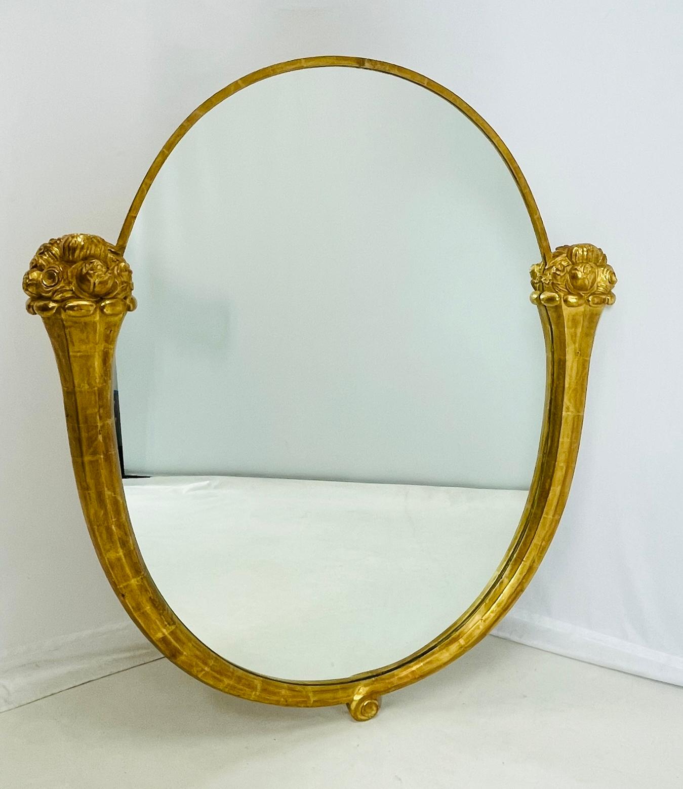 Miroir de forme ovale en bois doré à partie haute cerclée d'une bague en laiton doré et encadrée de deux cornes d'abondance.

Le cadre de ce miroir semble être ancien, le dos du miroir comporte un morceau de contreplaqué plus récent.

Apparemment