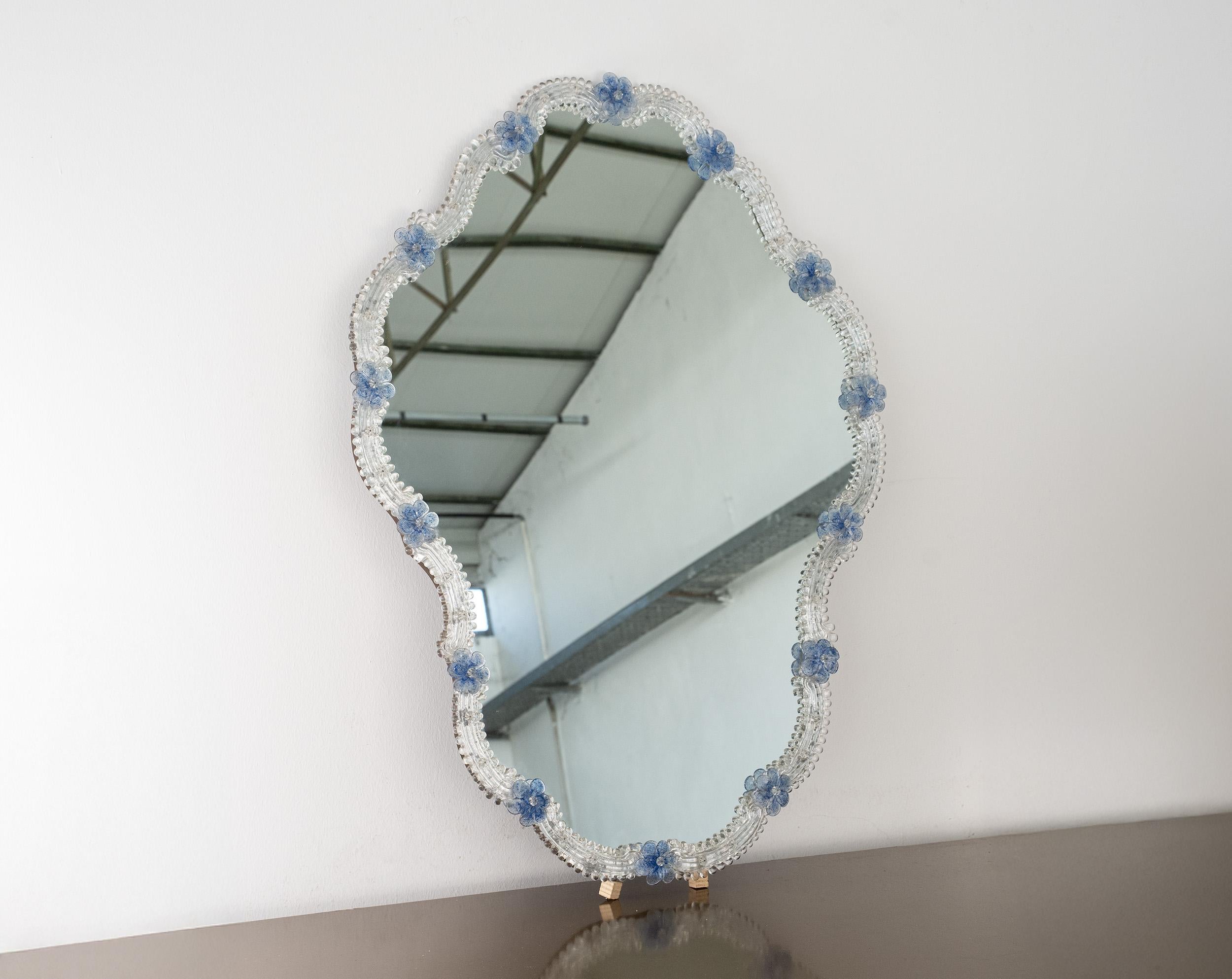 Great Wall Miroir vénitien en verre de Murano, transparent et détails de fleurs bleues
Un magnifique miroir mural vénitien vintage entièrement réalisé à la main en verre de Murano.
Le miroir est doté d'un support en bois avec une boucle de