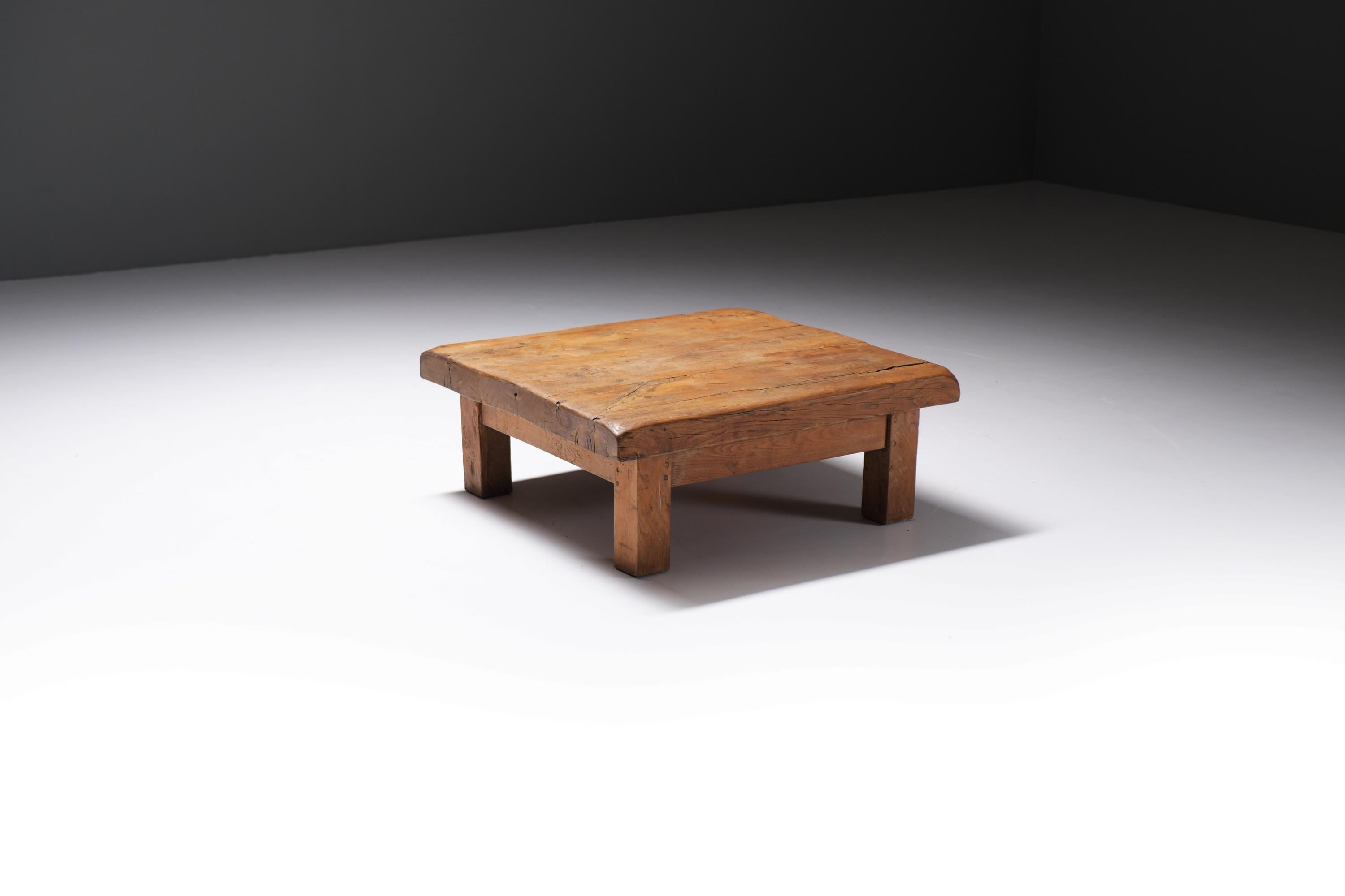 Stunning brutalist wooden coffee table with a four-legged base. Made of solid wood with a charismatic patina.
Produced in France (1950s)

Crafted from solid wood, its surface bears the marks of age and use, a beautiful patina that tells a story of