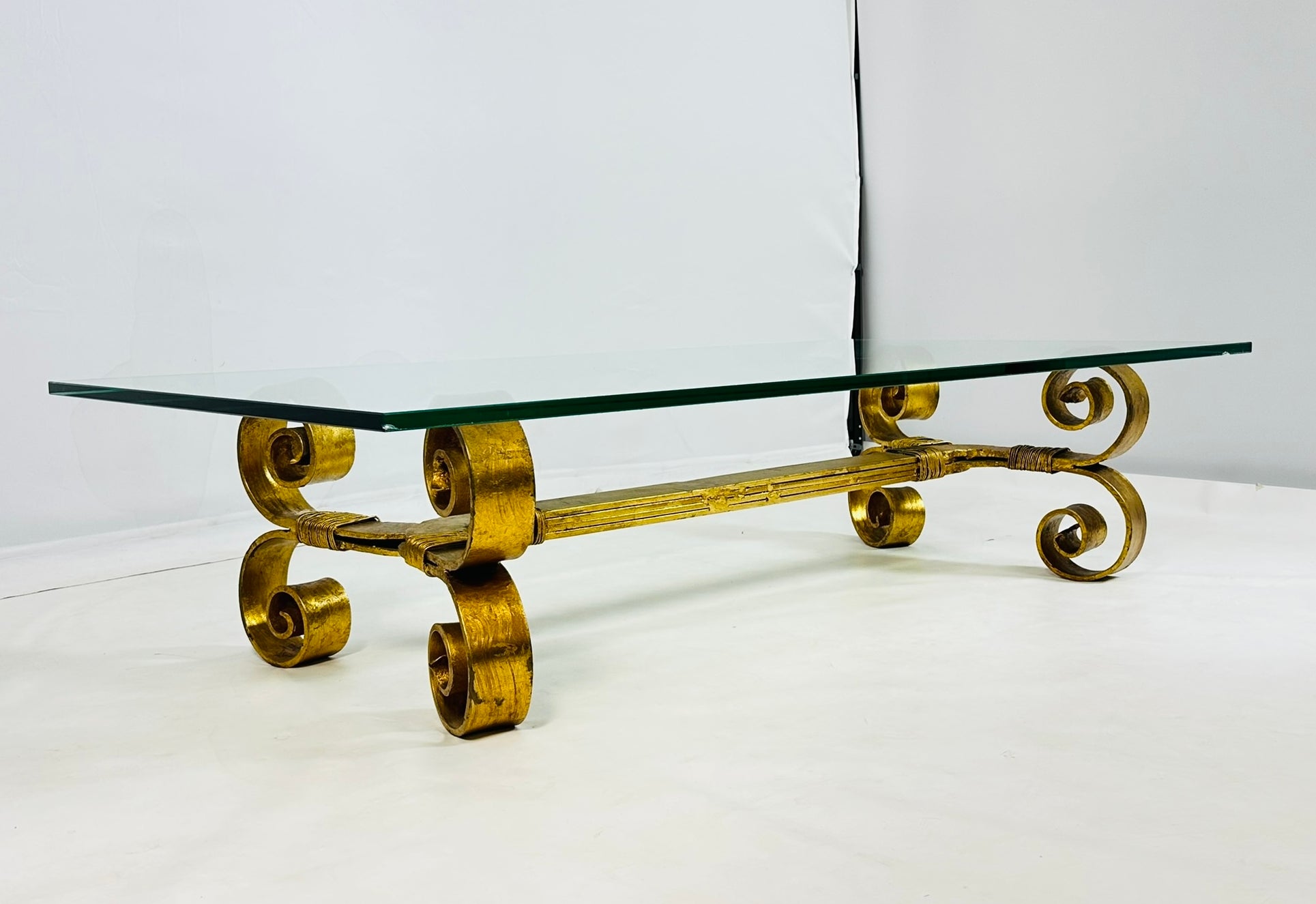 Wunderschöner Couchtisch aus Schmiedeeisen und Blattgold im Hollywood-Regency-Stil.

Schwerer, eiserner Metallsockel, mit Gold vergoldet. Elegante blühende Schneckenform mit schweren Drahtverzierungen. Hervorragende Handwerkskunst mit stabiler