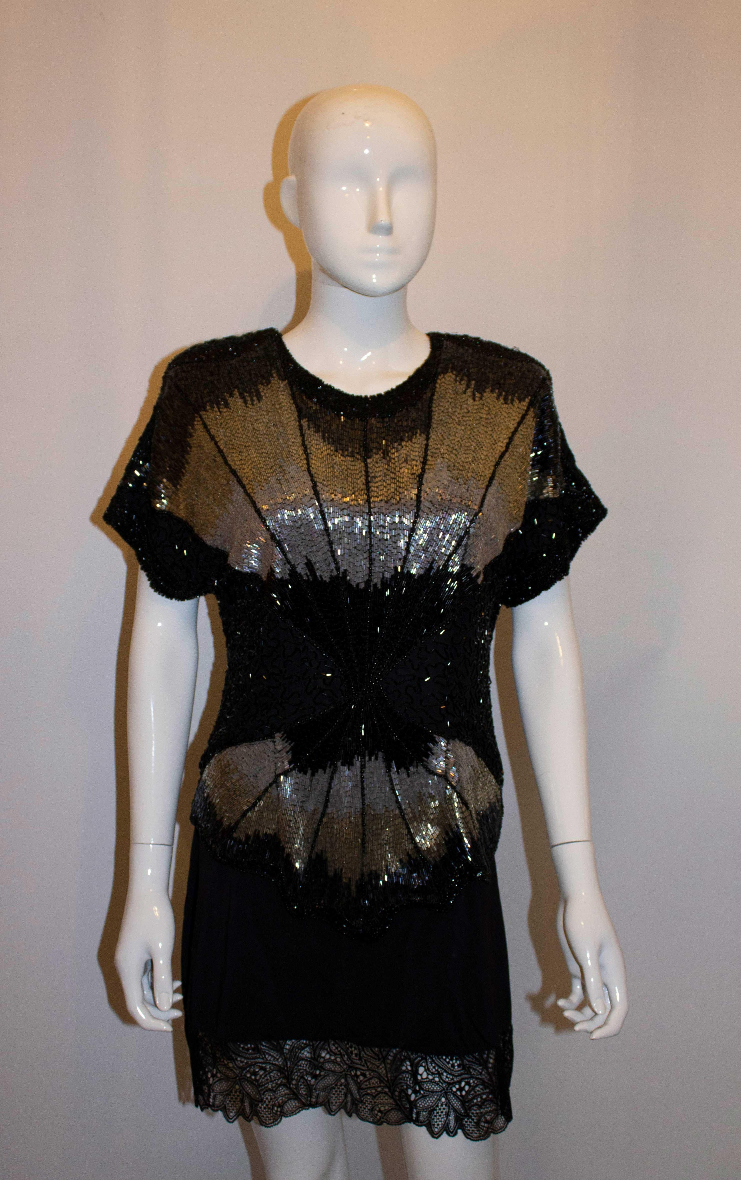 A head turning , wonderful deco style vintage beaded top. The outer fabric is silk, and is decorated in a stunning mix of beads and colour. The top has a back zip opening and sacllop edged hem.
Measurements: Bust up to 37'', length 26''