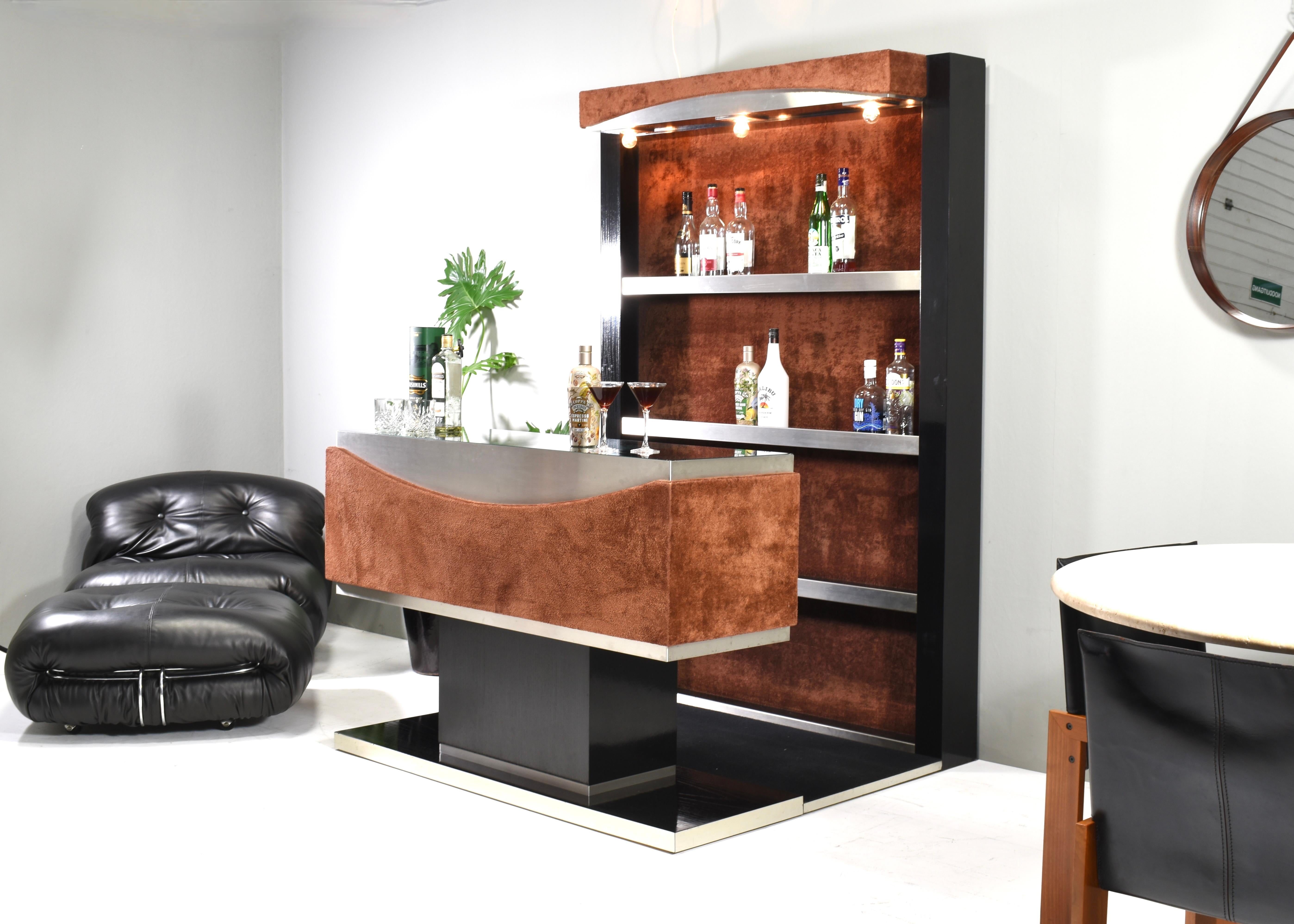 Stunning 1970's Italian cocktail dry bar in Ebonized wood and Brown teddy fabric covering. The bar is designed by or in the style of Willy Rizzo.
It features beautiful brown pluche teddy covering, black ebonized wood, lighting, chrome details, glass