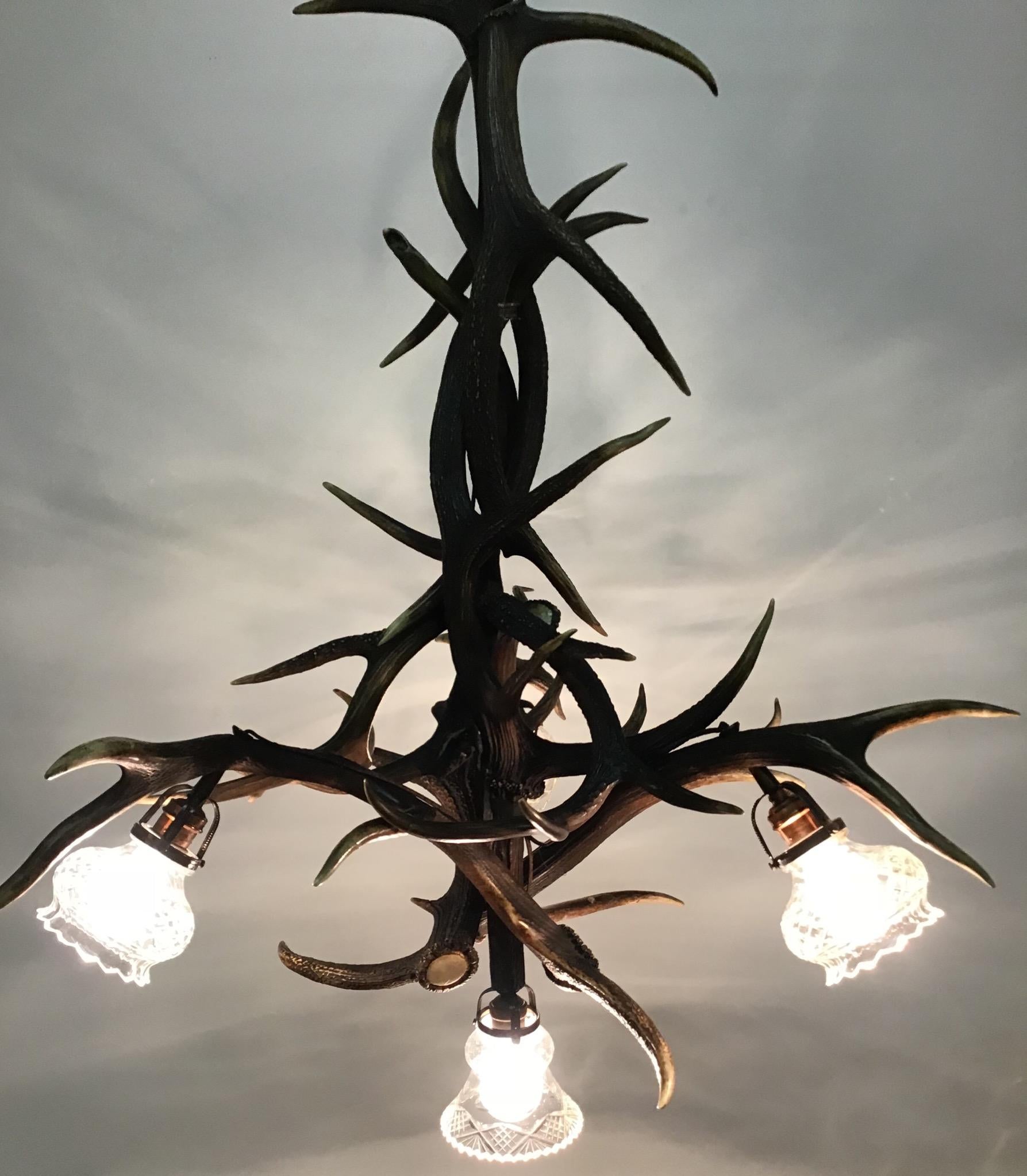 An antique hunting antlers  chandelier, Germany, circa 1900s.
This chandelier is made of antler and four original cut crystal shades.
Socket: Four x e27 (Edison) for standard screw bulbs.

 