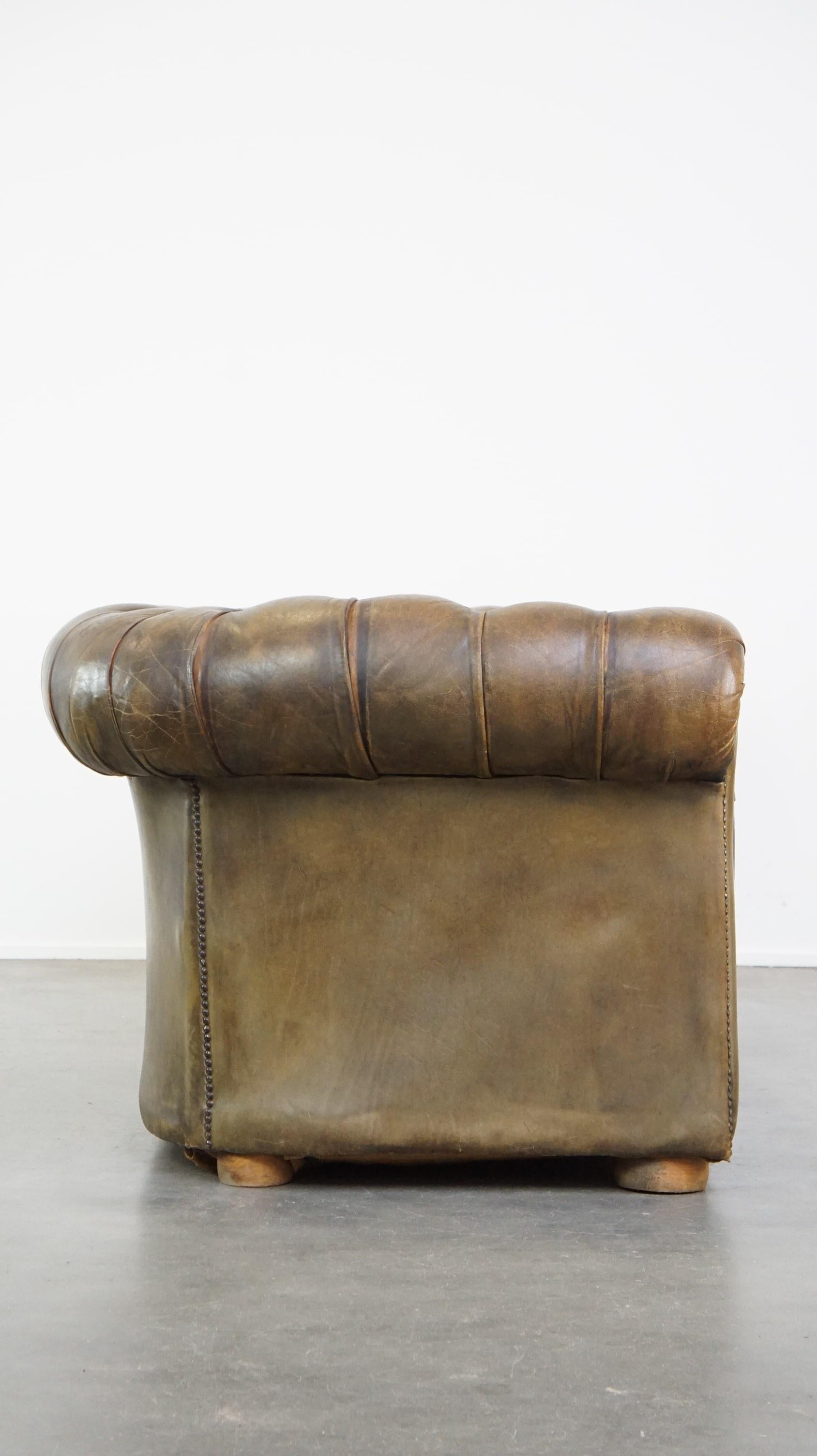 Ce magnifique canapé Chesterfield dans sa belle couleur verte attire tous les regards. Il a récolté quelques cicatrices au cours de sa vie plutôt longue, mais à notre avis, cela ne fait que l'embellir. Et soyons honnêtes, n'est-ce pas le canapé