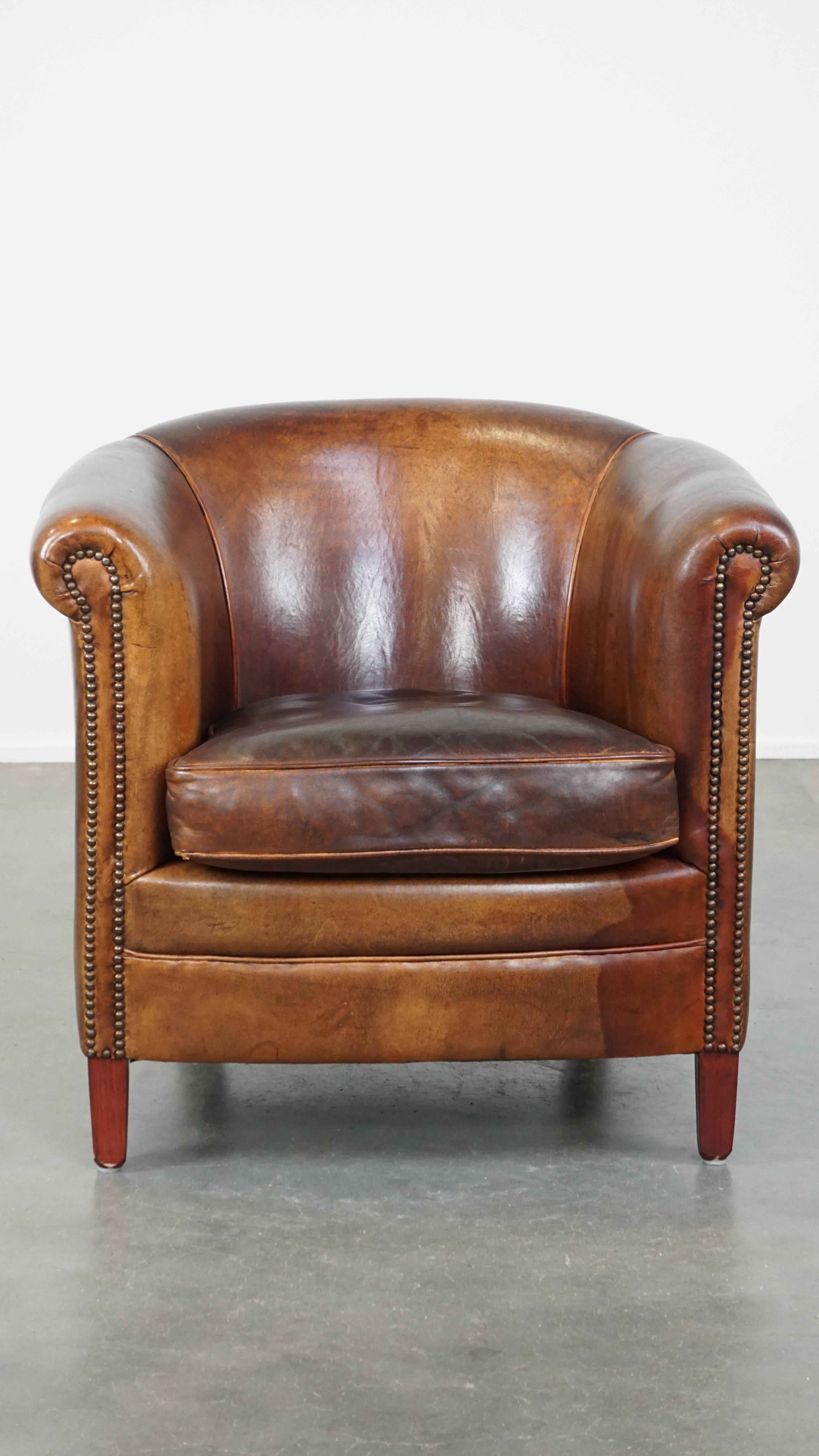 This fantastic cognac-colored sheepskin leather club armchair effortlessly fits into almost any interior. It features fine detailing with decorative nails and exudes a timeless yet sturdy appeal. Over the years, it has developed a beautiful patina,