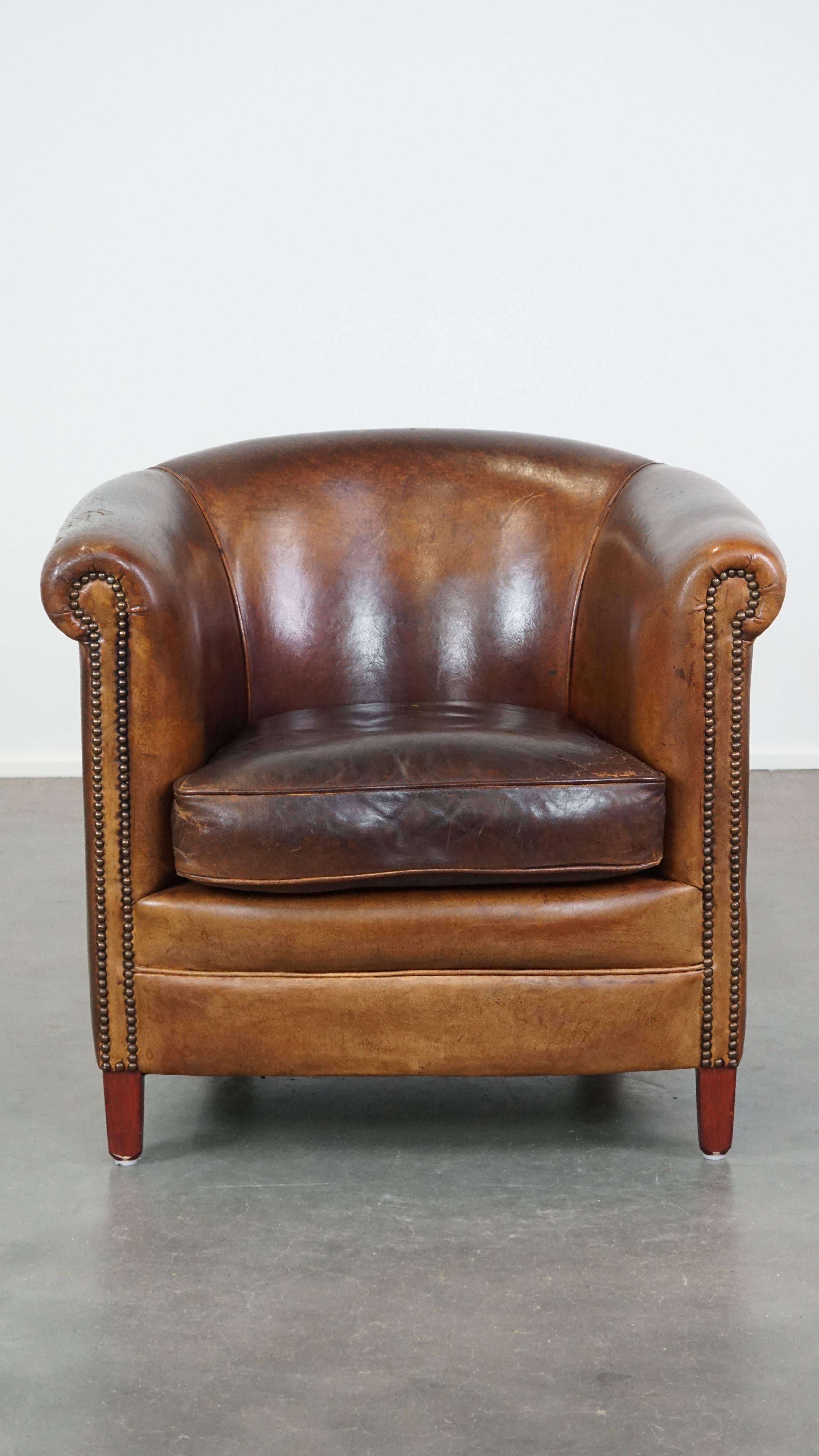 This fantastic cognac-colored sheepskin leather club chair fits seamlessly into almost any interior. It features precise craftsmanship with decorative nails and boasts a timeless, sturdy appearance. Over the years, it has developed a beautiful