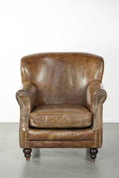Sturdy cowhide armchair in a beautiful subtle size with a wonderful patina
