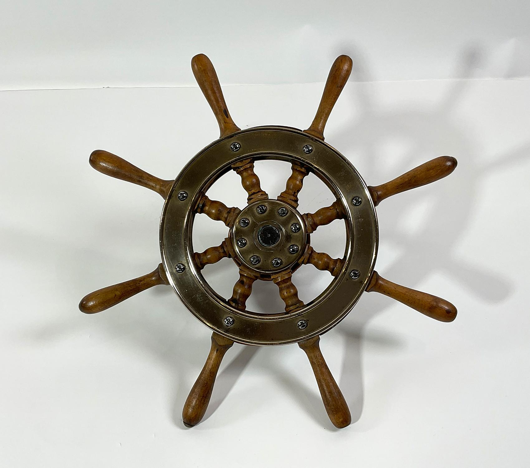 Small boat or yacht wheel of maple and brass. Wheel is fitted with a shaft and rudder pulley. Very decorative and authentic maritime relic. Circa 1920. Measure: 15 inch.