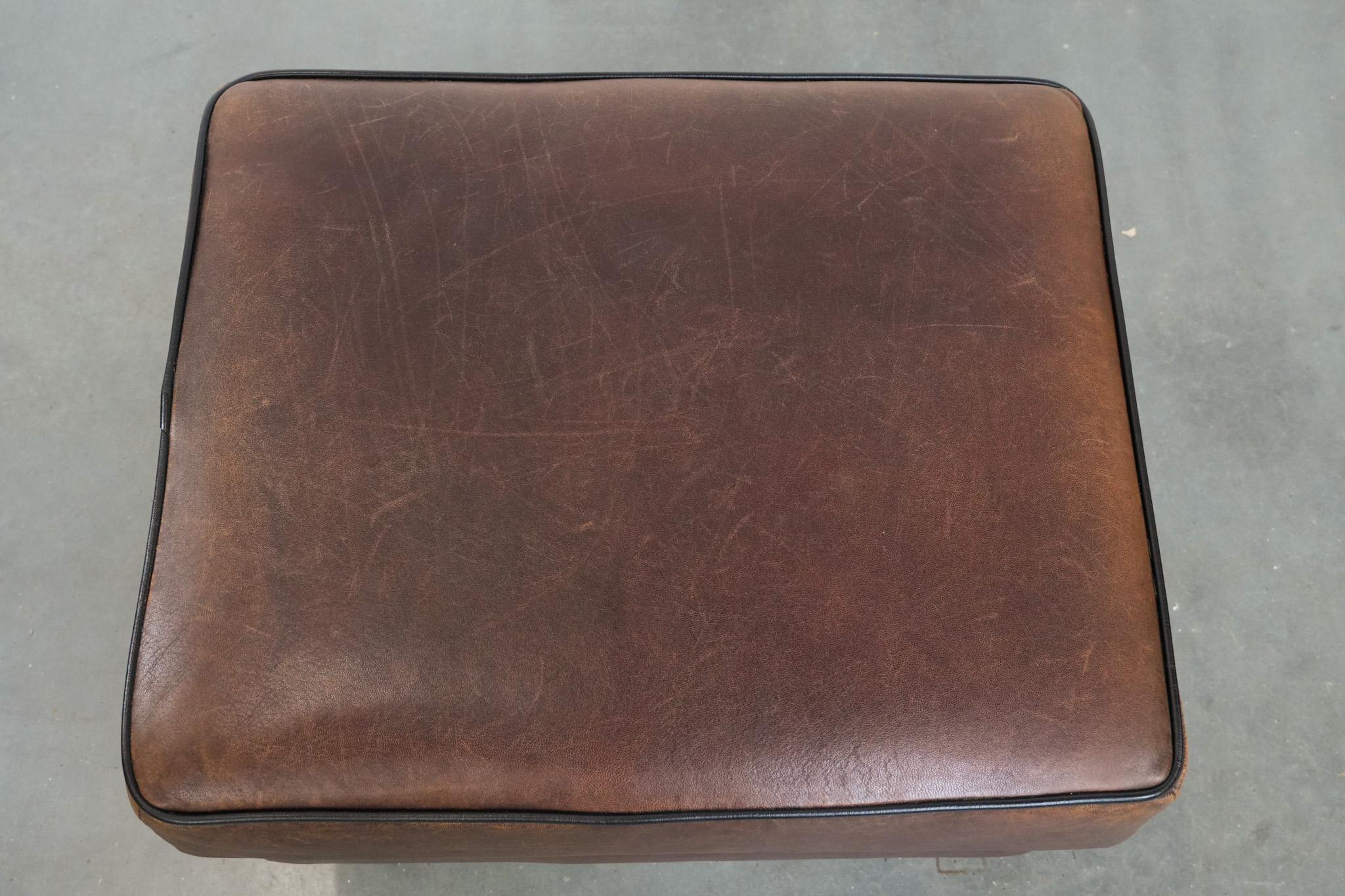 Pelle Robusto pouf in pelle di pecora d'epoca di grandi dimensioni con profili neri in vendita