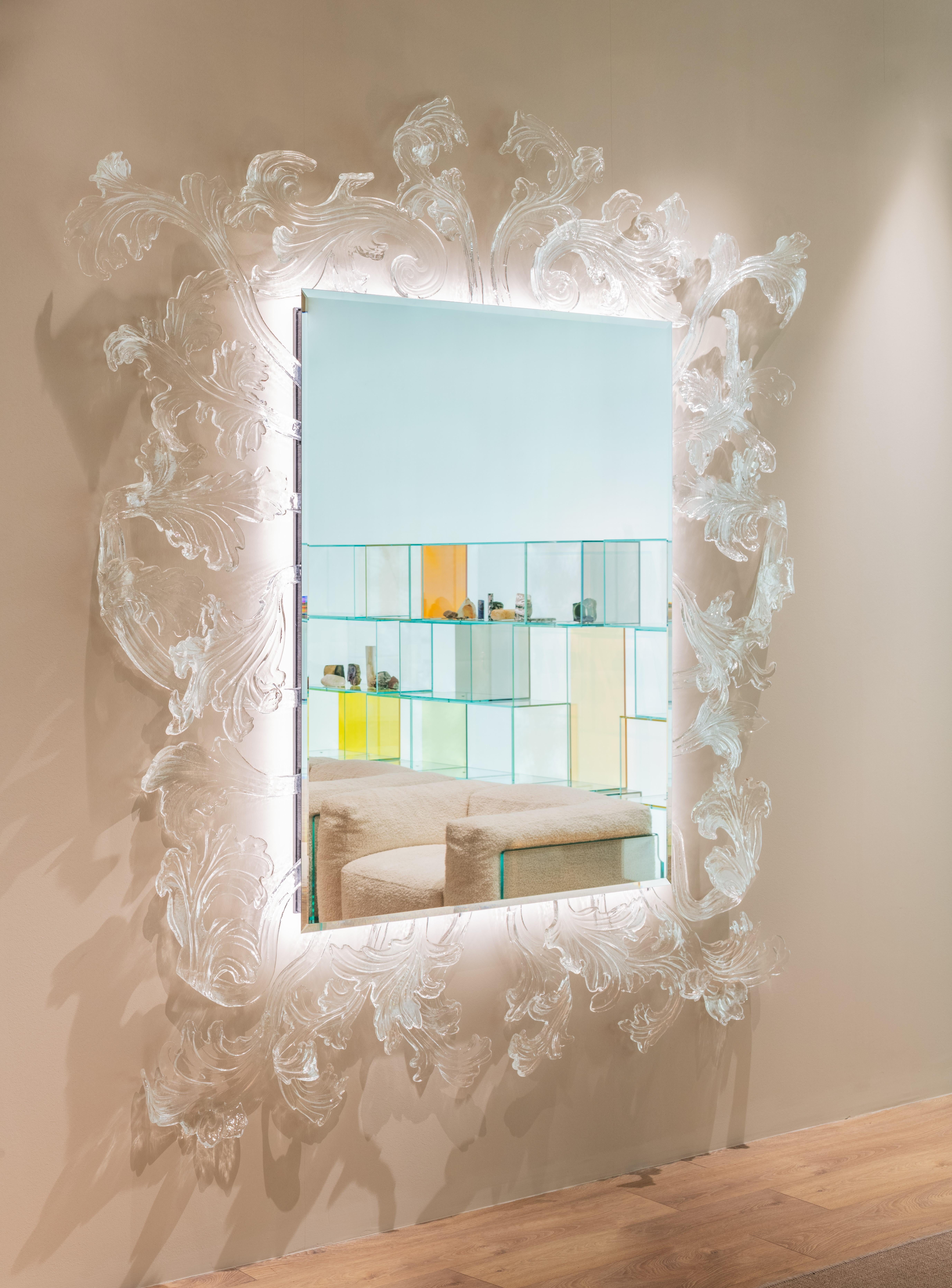 A truly magnificent mirror with Murano glass frame, achieved through a complex and refined hand-made production process, making each piece unique and unrepeatable. The frame is composed of various elements which are fixed to a wall hanging structure