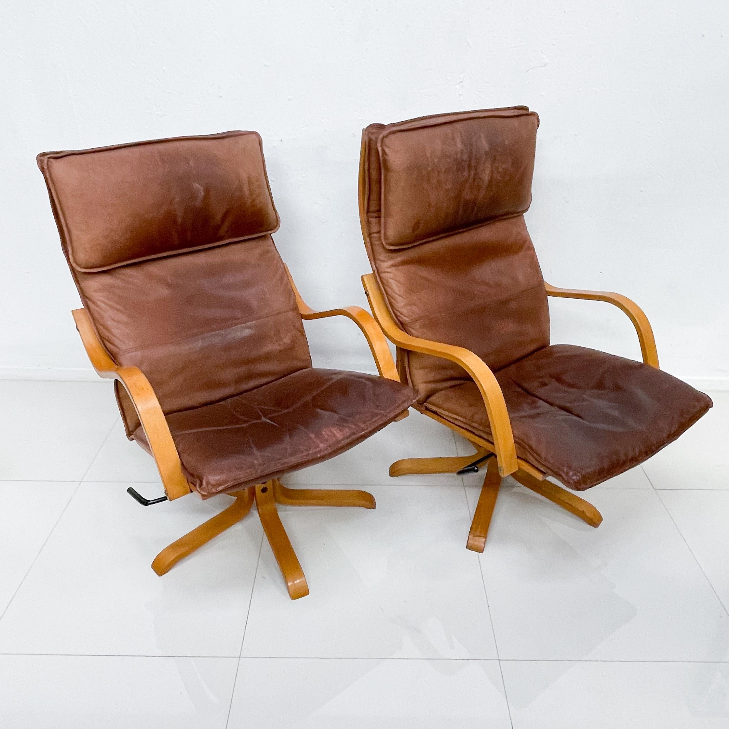 1960s Scandinavian style set of two vintage tall leather lounge chairs on a blonde wood star base Italian Swiss design made in Italy. Manner of De Sede and Vatne Mobler.
 No information on the maker available. 
Price is per set of two chairs.