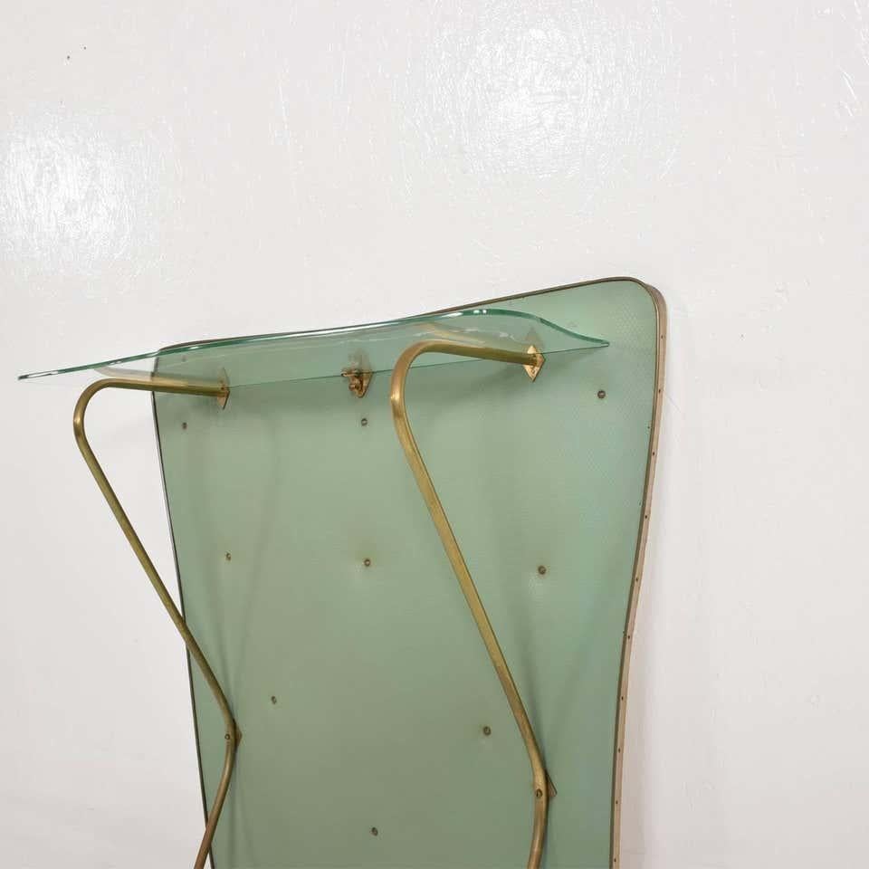 Mid-Century Modern attributed to design of Gio Ponti Stylish Regency modern wall console in mint green. Made in Italy circa late 1950s.
Wood board covered in a delicate airy mint green. Elegant brass frame legs and brackets to support the sculptural