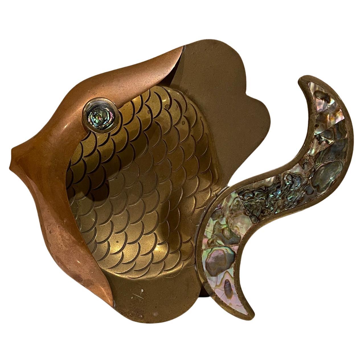 Decorative fish dish
Mexico style of Los Castillo Decorative Ashtray (it can be hung on the wall as an art sculpture or placed on a table as catch all tray).
Signed underneath Chavez 99.
Brass, copper (married metals) & abalone.
1.5 tall x 6 w x