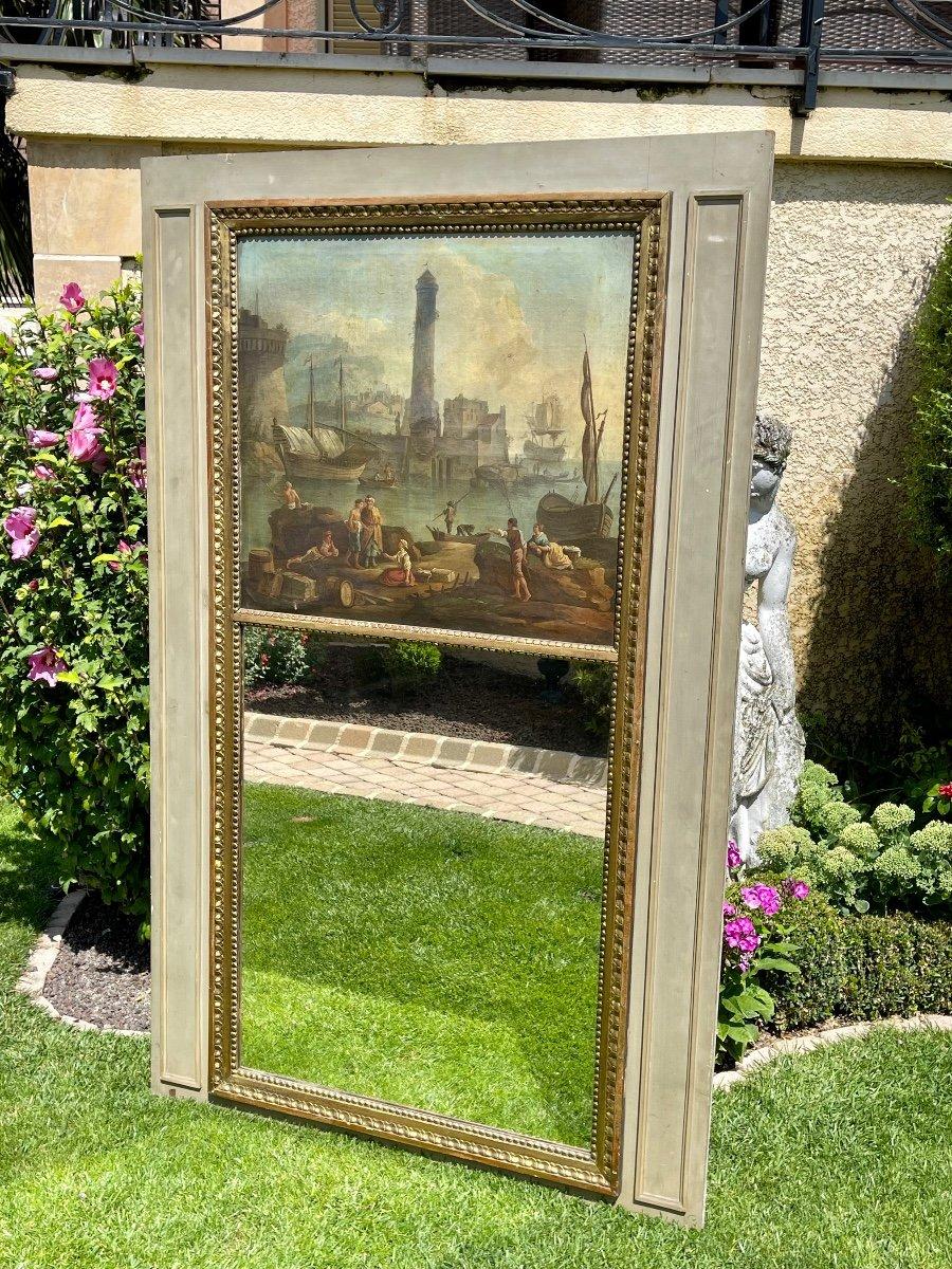 Lovely Louis XVI trumeau - Directoire in lacquered wood, old mirror and oil on canvas. 18th century period. The canvas is in its original state on a period wooden frame. The subject of the painting represents a lively port of fishermen, sailboats,