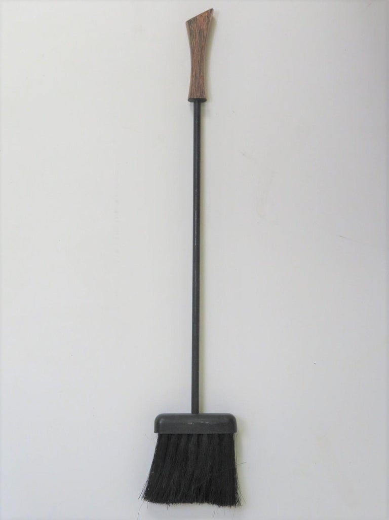 Very nice three piece fireplace tools ensembled in a George Nelson style of textured copper color handles and black wrought iron tool. Featuring a poker, shovel and broom all hanging from a copper colored wall mount. Very smart, very Mid-Century