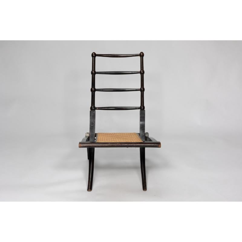 EW Godwin Style of. An Aesthetic Movement ebonized folding chair with bobbin details to the backrest and a new cane seat. 
This listing is for one chair. We also have a pair available.