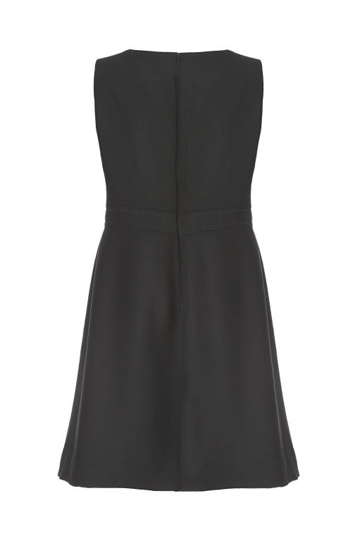 This classic 1960's mod style mini dress is by designer Bernard Freres and is effortlessly stylish, simple and easy to wear.  The dress is sleeveless and features a sweetheart neckline with two large black and gold statement buttons on the waistband