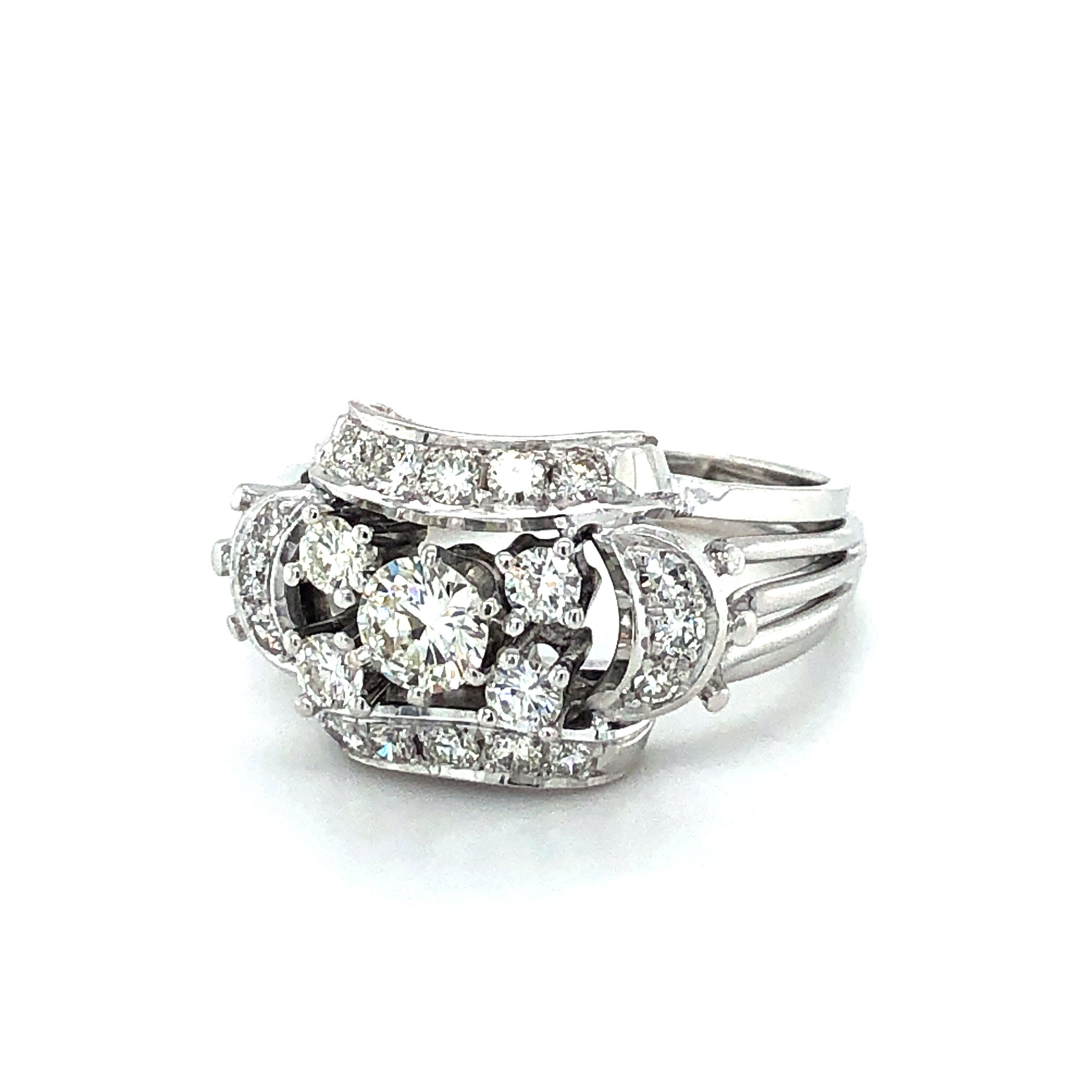 Playful ring in 18 K white gold. Designed as a cluster of five brilliant-cut diamonds; embedded in 16 brilliant-, and single-cut diamonds. The prong set center stone weighs an approximate 0.40 ct and is of G/H-vs quality. The remaining diamonds add
