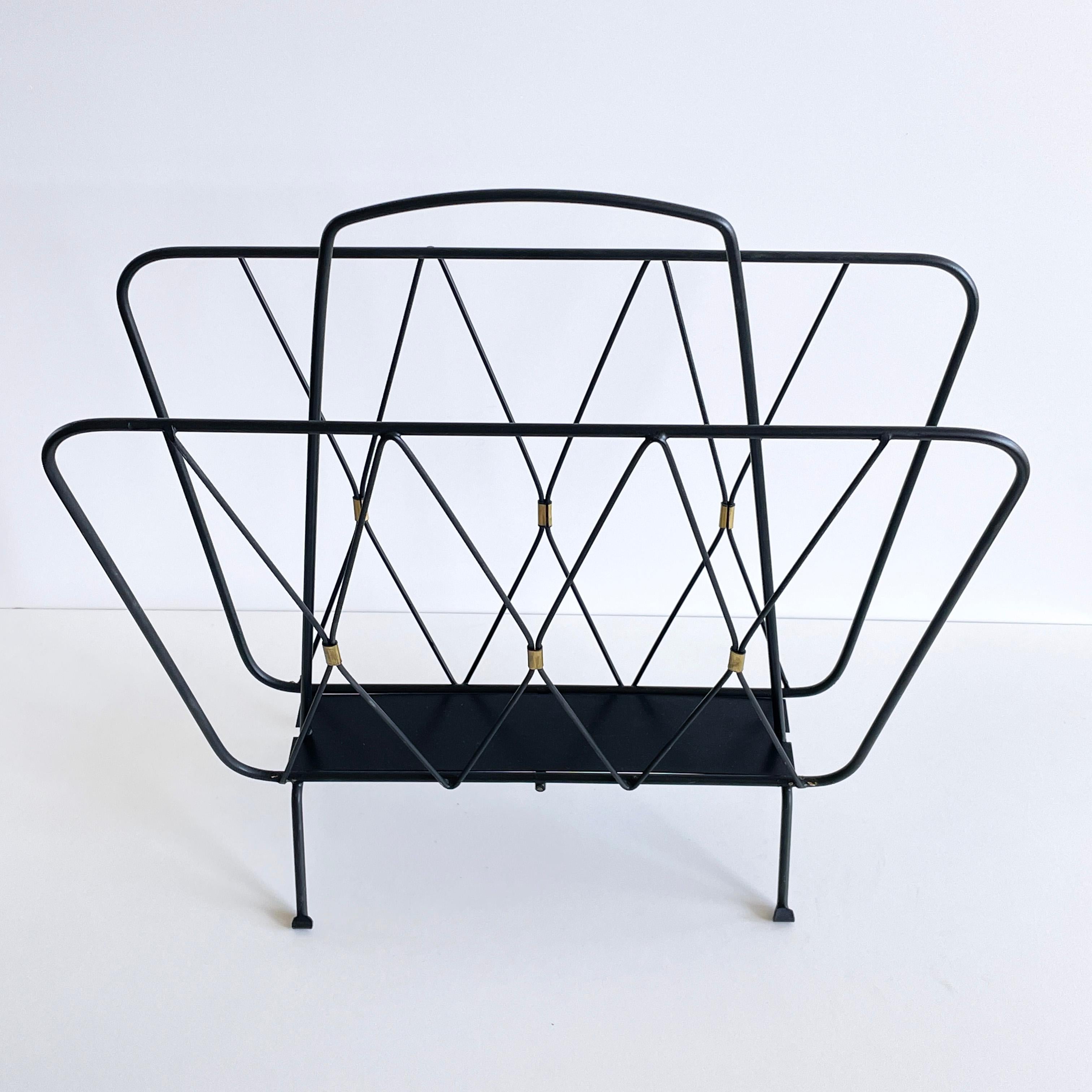 Elegante soporte para revistas/periódicos de los años 60. Armazón de metal con detalles de latón.
Medidas: Altura: 48 cm  Anchura: 42 cm  Profundidad: 22 cm
En excelente estado, con pocos signos de uso. 
