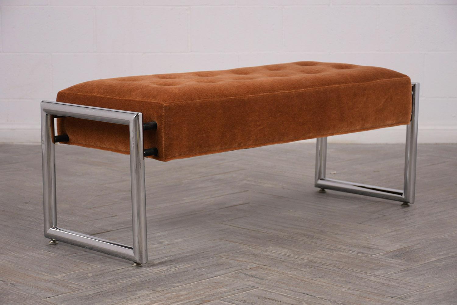 Modernish bench with tubular chrome legs. The seat has been professionally reupholstered in a burnt orange Mohair fabric color, with square tufted design. Has top-stitch details. Solid and sturdy frame with a comfortable seat. Ready for any home or