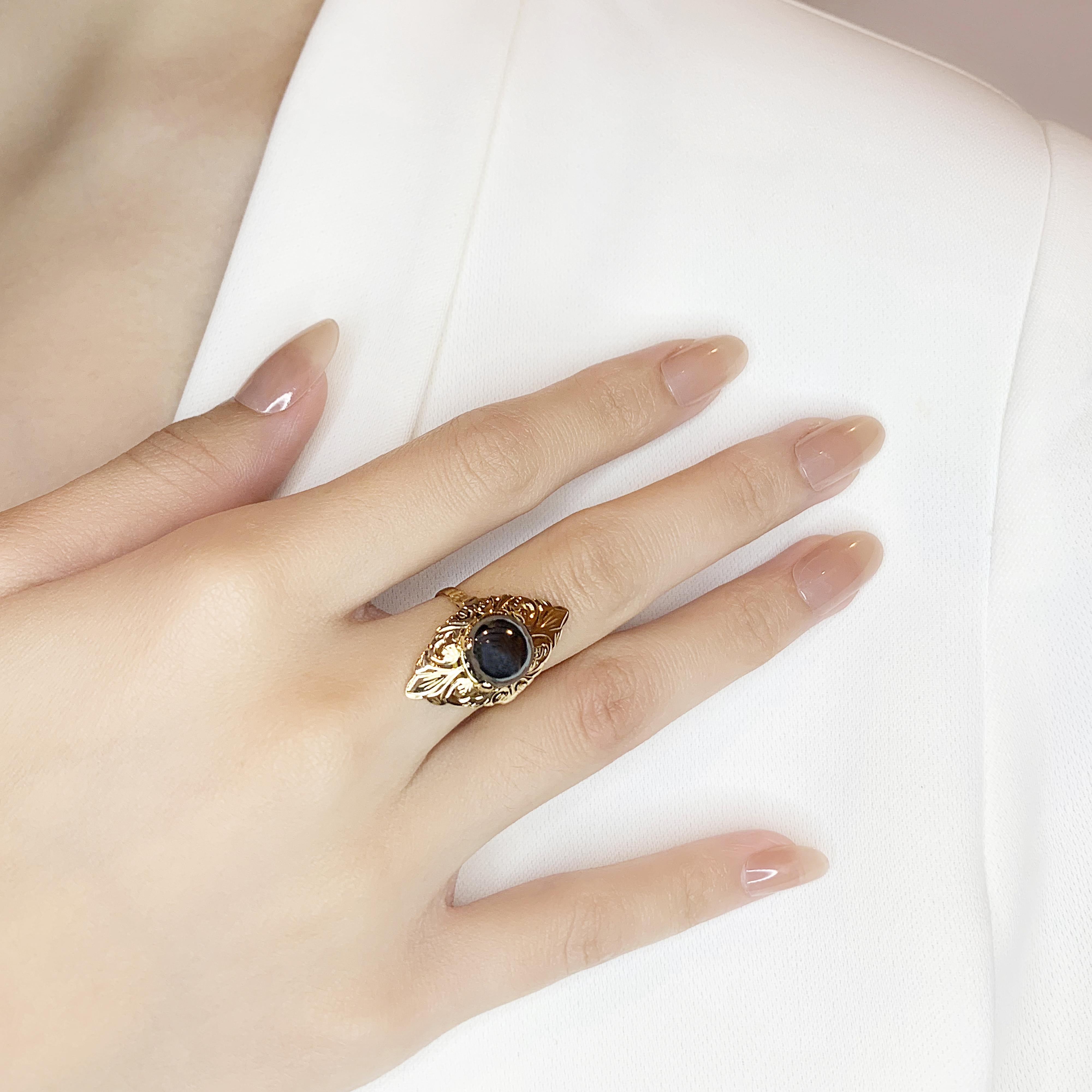 This striking ring features a single round brilliant onyx stone, weighing 1ct, set in 14K yellow gold. The rich black color of the onyx contrasts beautifully with the warm tones of the yellow gold. The entire piece has a total carat weight of 1ct