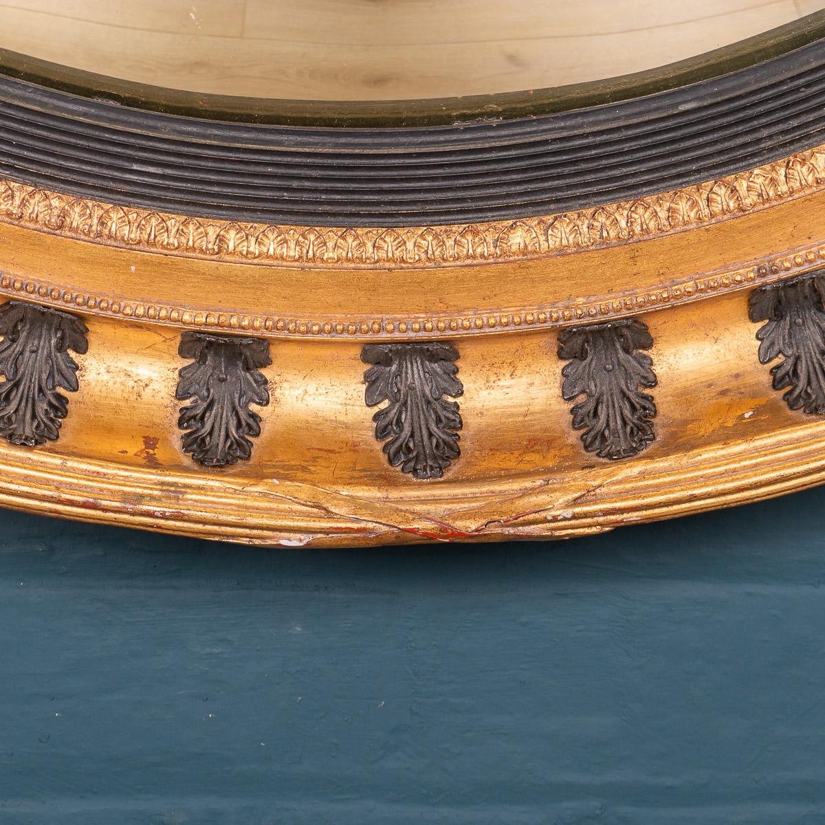 Truly massive convex mirror, with gilt frame and applied black acanthus leaves, late 20th century, reputedly retailed by Harrods, London. Convex mirrors played an important role in the running of the Regency household. Often placed in the dining