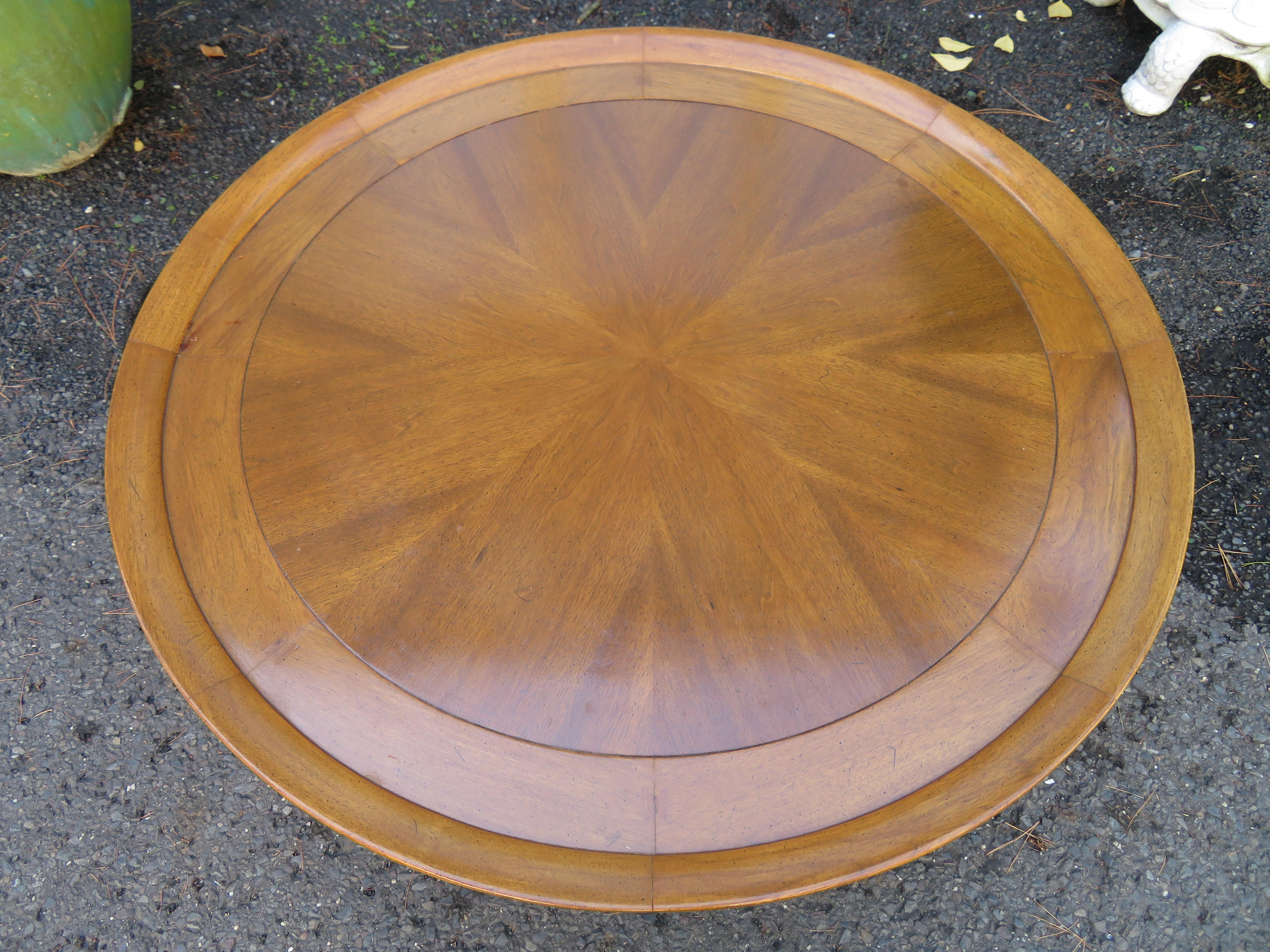 Lovely round coffee table part of the Sophisticate line by Tomlinson. This table features a coved top edge with a sunburst pattern figured butternut, and wood butterflies mortised into the joints. This table measures 16