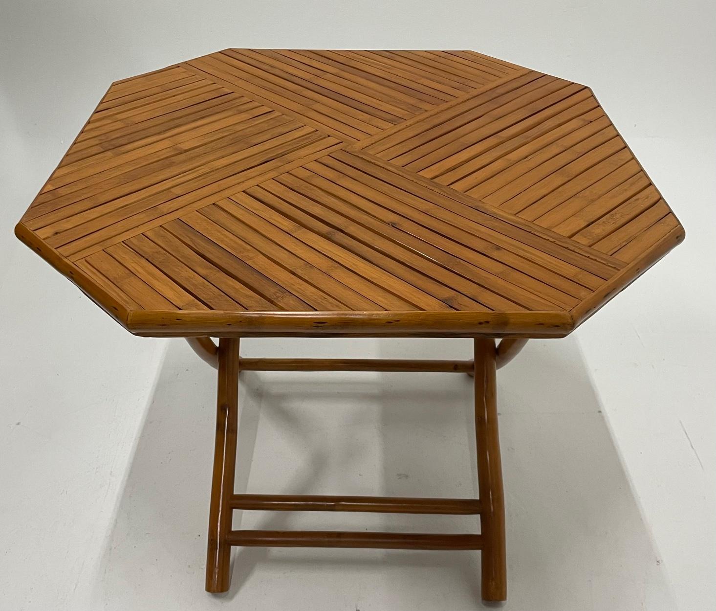 A schnazzy 8 sided bamboo table with folding legs having beautifully crafted top with triangular sections of bamboo laid out in geometric design. Makes a terrific center table or breakfast table. Great shape and form.