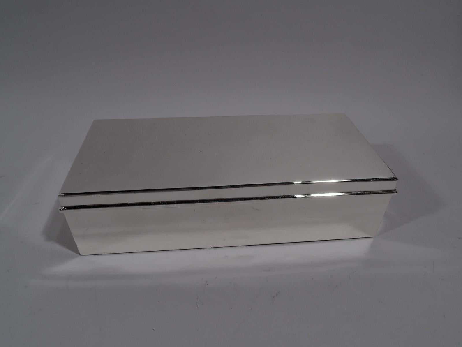 Stylish and modern sterling silver desk box. Made by Tiffany & Co. in New York. Rectangular with straight sides. Cover flat and hinged with molded rim. Box and cover interior cedar-lined and partitioned. Hallmark includes pattern no. 23093 and