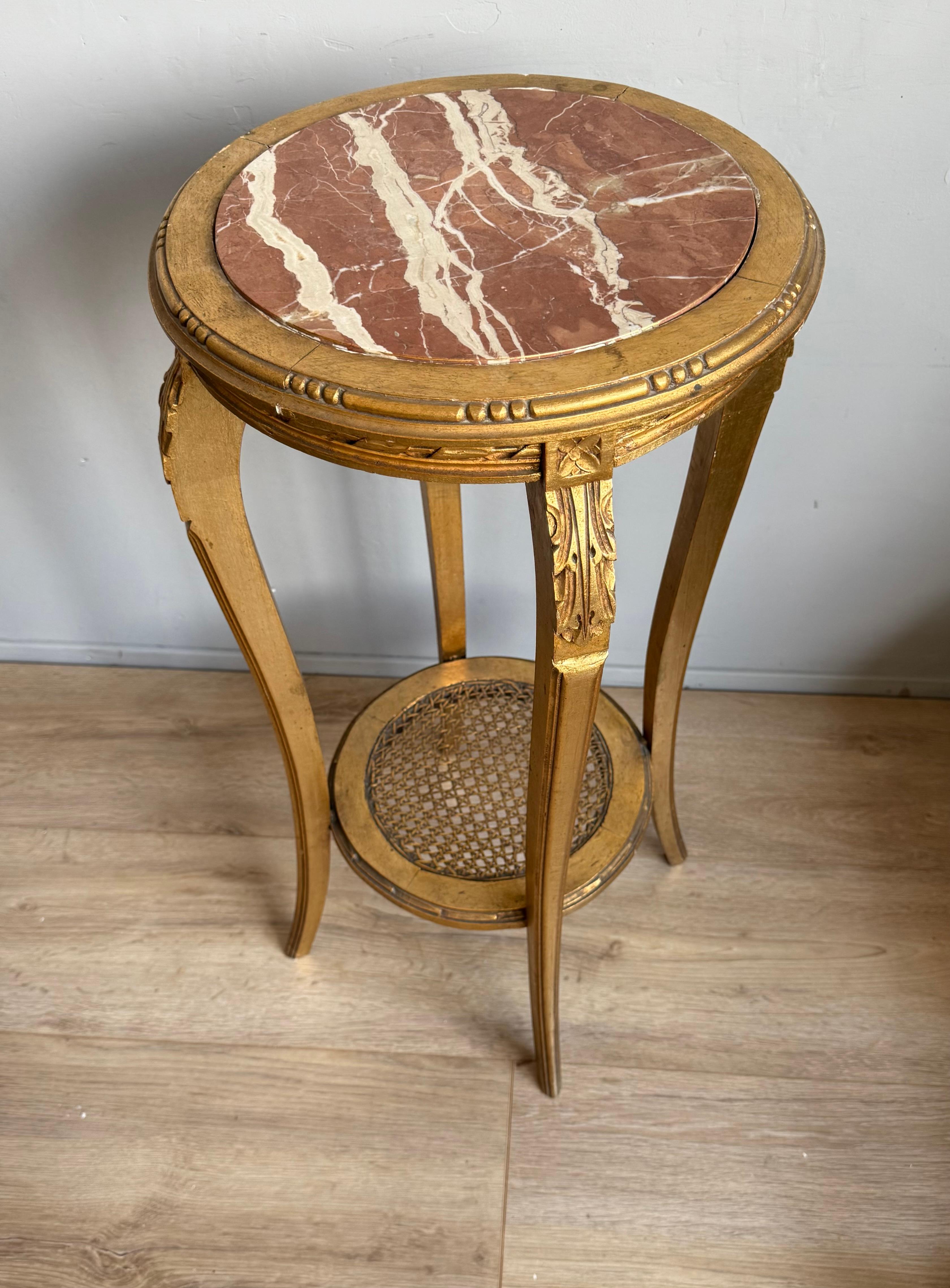 Antiguo Guéridon francés de madera dorada con tapa de mármol y estante de caña, Renacimiento Luis XVI.

Añade un toque de elegancia francesa atemporal a tu interior con este exquisito guéridon de madera dorada estilo Luis XVI, fabricado a mano en