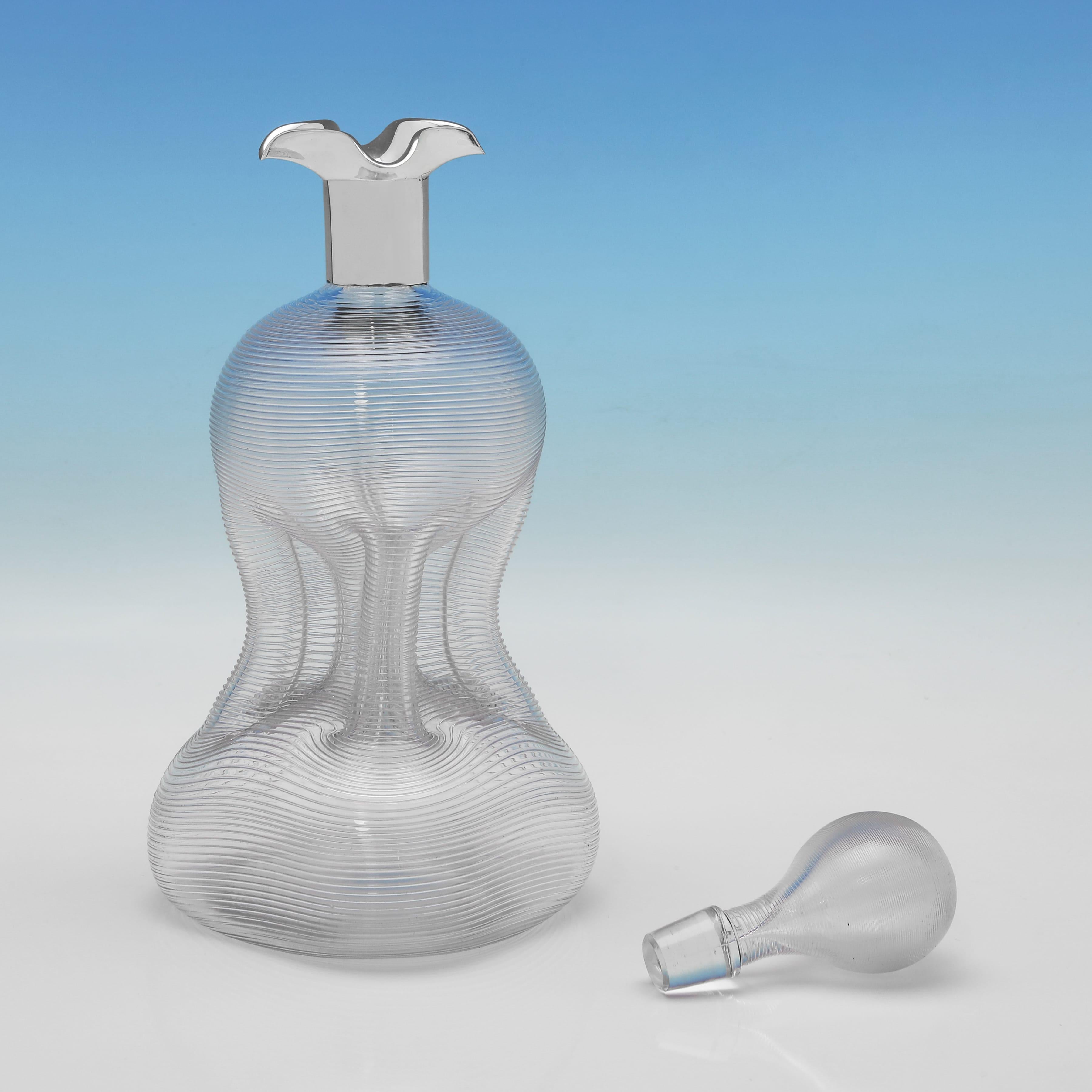 Poinçonnée à Sheffield en 1896 par John Round & Son Ltd, cette belle carafe victorienne en verre ancien et en argent sterling présente des détails nervurés sur le corps en verre et le bouchon, ainsi qu'une monture en argent uni avec quatre becs