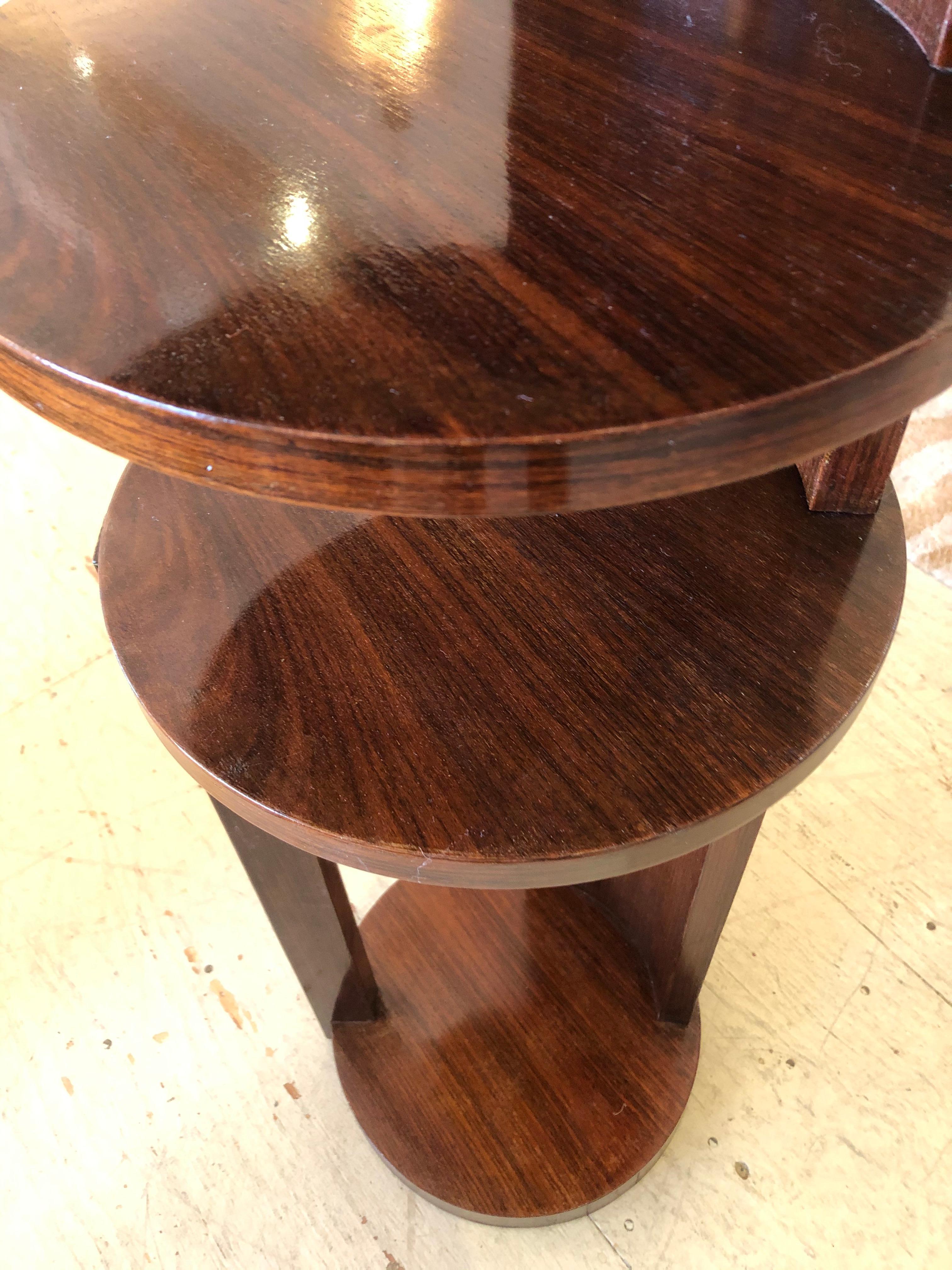 A very unusual chic round multi level étagère, stand or end table having stylish Art Deco lines, 4 tiers, and gorgeous richly grained dark rosewood veneer.
Distance between the levels, 23 H to bottom of first shelf, 5.75 between 2nd and 3rd, 5.5