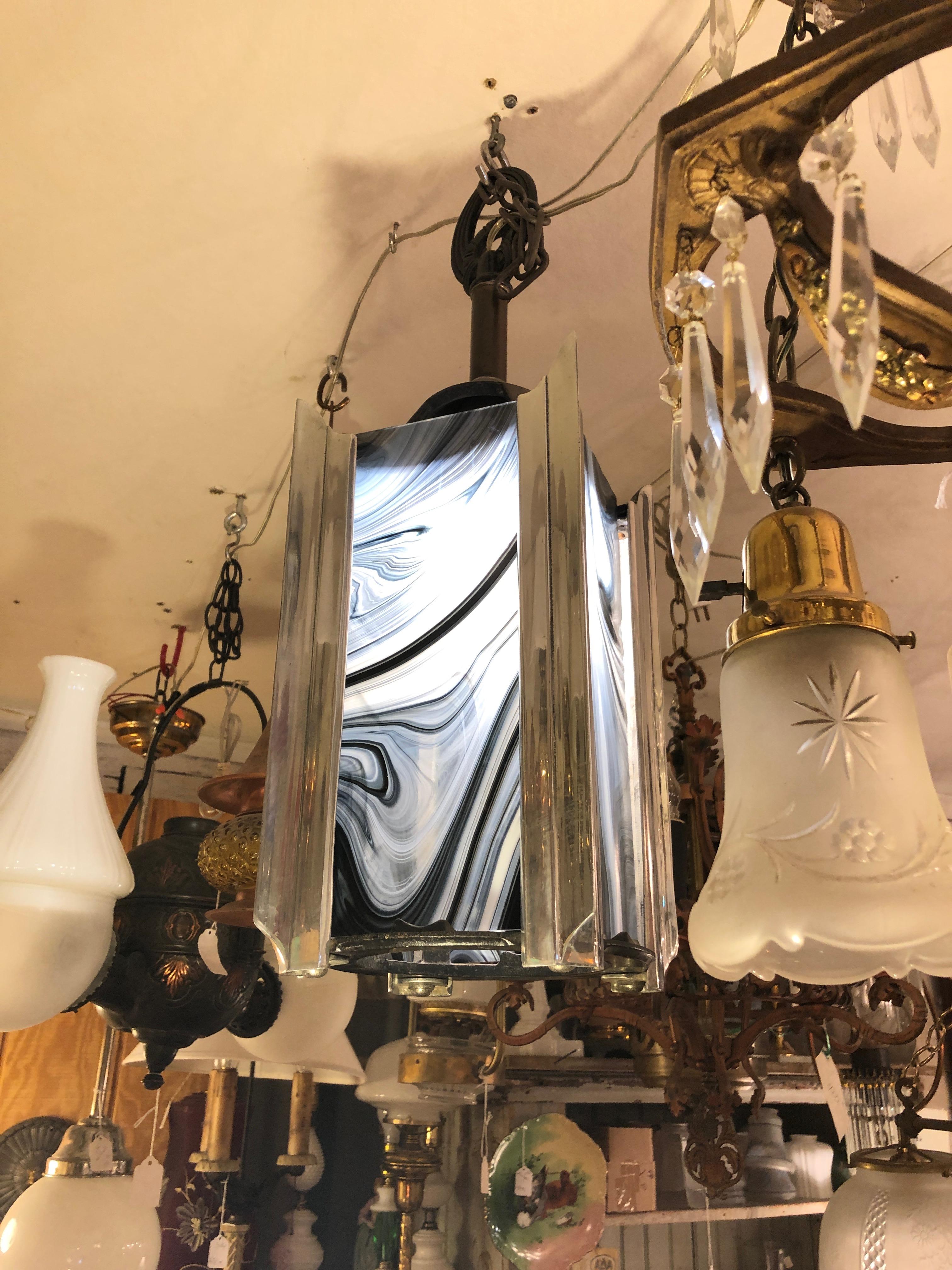 A striking Art Deco lantern shaped pendant having black, grey and white art glass and chrome frame with iron hanger at the top. 1.5 ft of chain included.