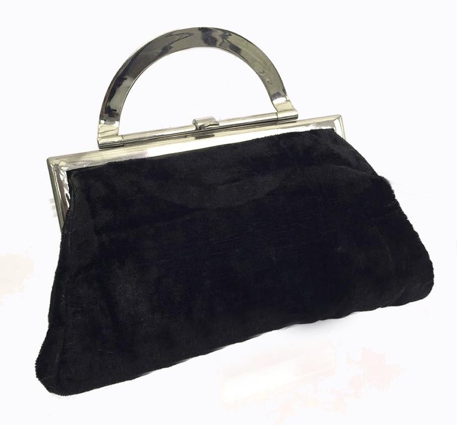 For your consideration is this superbly stylish and rare 1930s black silk velvet clutch bag originating from England. Features a chrome frame and clasp, the semi-circular front section of the chrome lifts up to form the handle if so wished, or you
