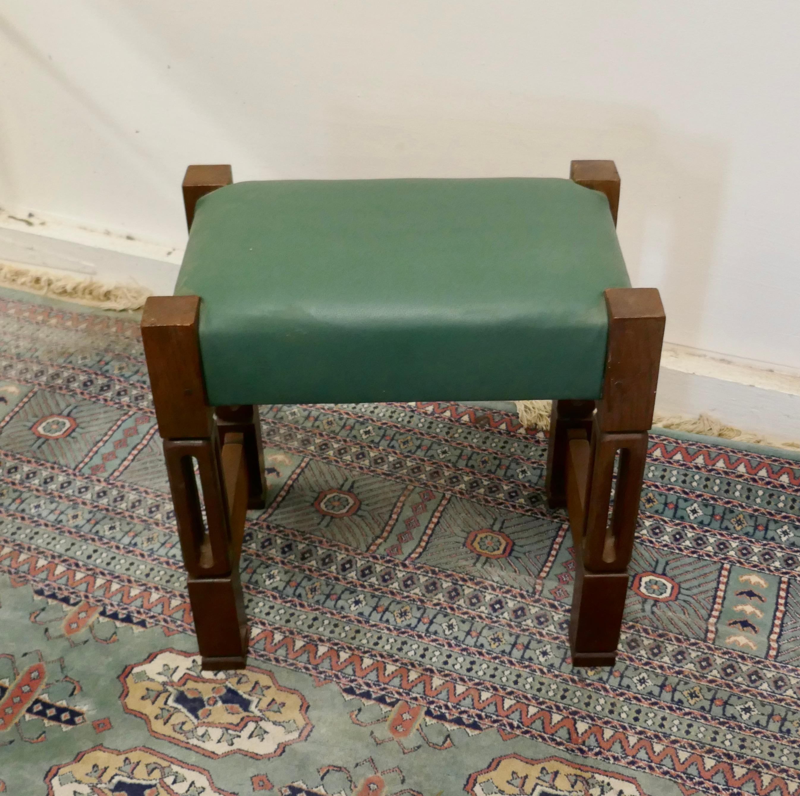 Stylish arts and crafts oak and leather stool

This is a superbly designed Arts and Crafts piece, it is made in oak with hollow carved legs and a green leather seat.
The stool is in good condition and the upholstery is new
The stool is 17” high,