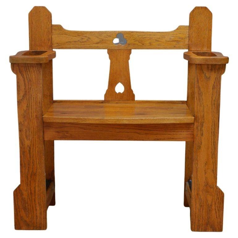 0225 Very attractive Arts and Crafts oak hall bench, having shaped back rail and round seat, raised on front and back uprights with umbrella compartments and original removable drip trays below. The bench is solid, sturdy and wobble free, all in