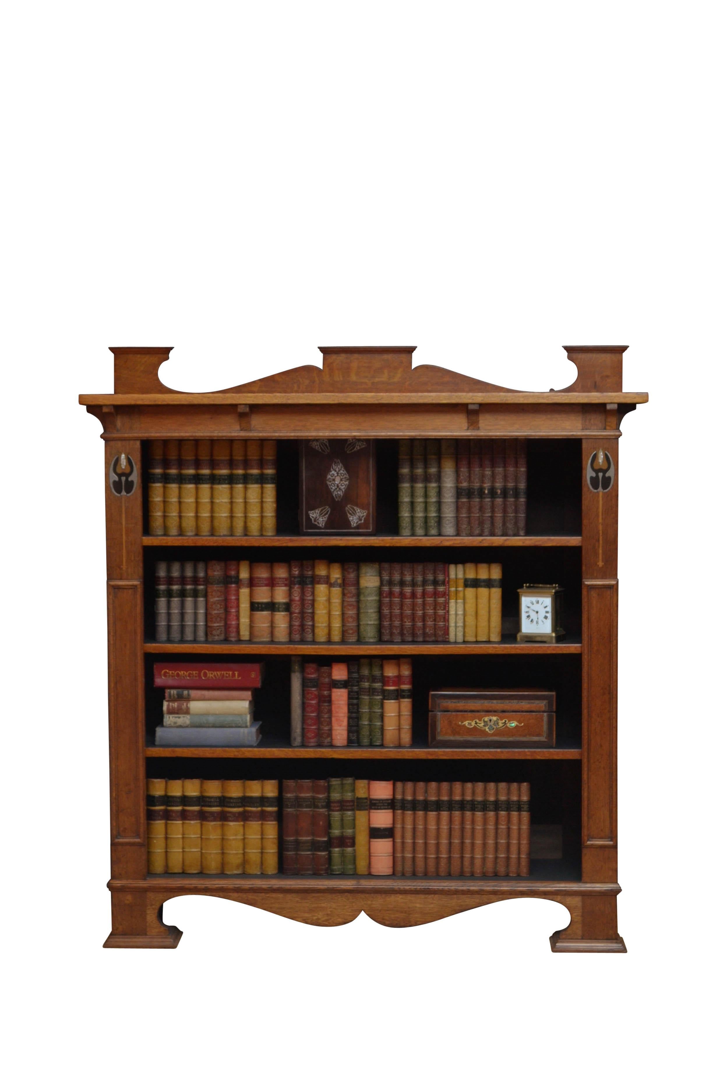 K0477 exceptional solid oak Arts & Crafts / Art Nouveau bookcase of soft and mellow colour, having shaped upstand to the back edge, oversailing top with shaped brackets below and 3 height adjustable shelves flanked by floral inlays and moulded