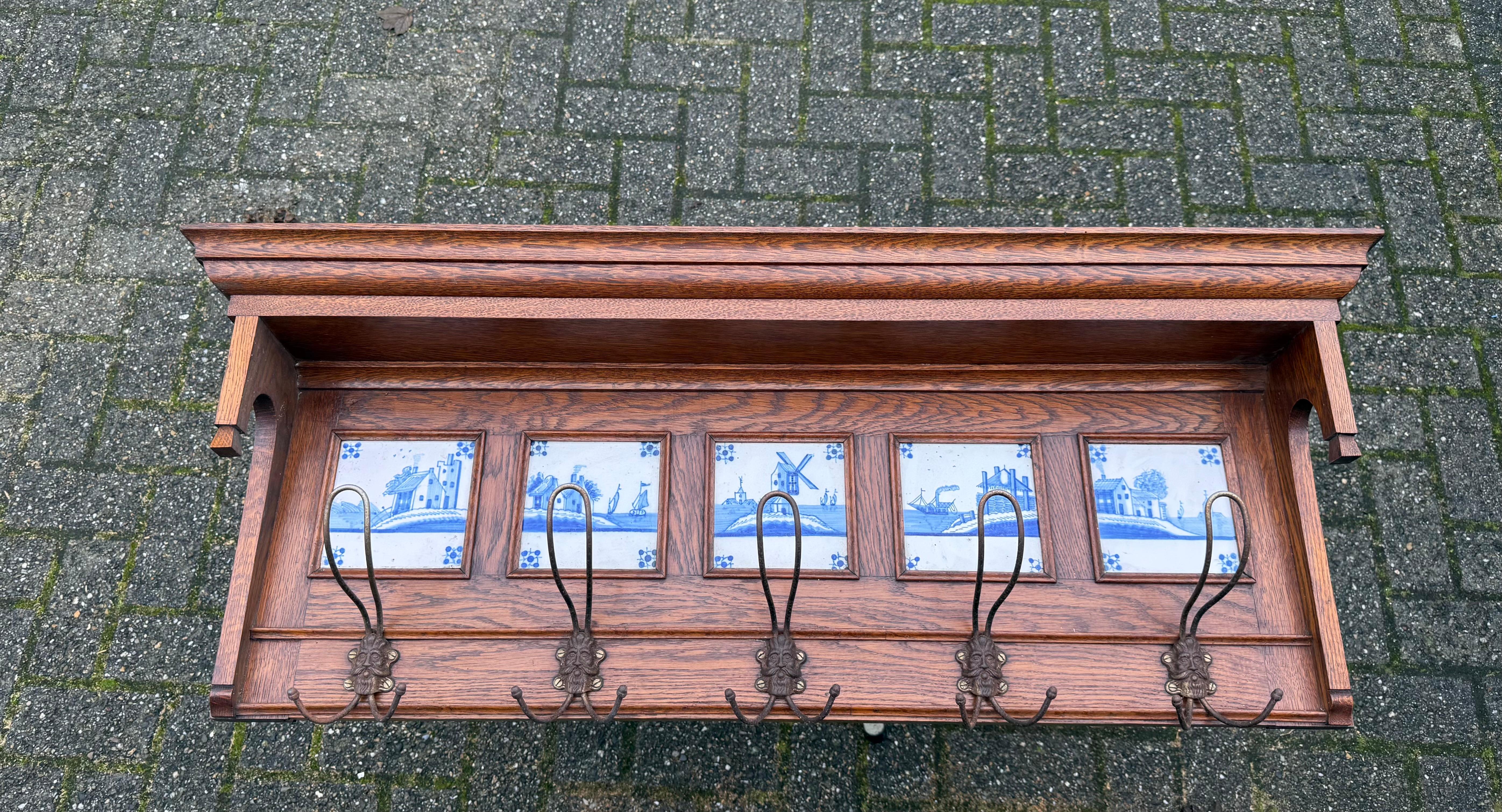 Porte-manteau mural au design époustouflant et en bon état, avec peintures de paysages sur carreaux de Delft.

Ce rare et très élégant porte-manteau Arts & Crafts est en très bon état et le superbe cadre est entièrement en chêne tigré. Grâce à sa