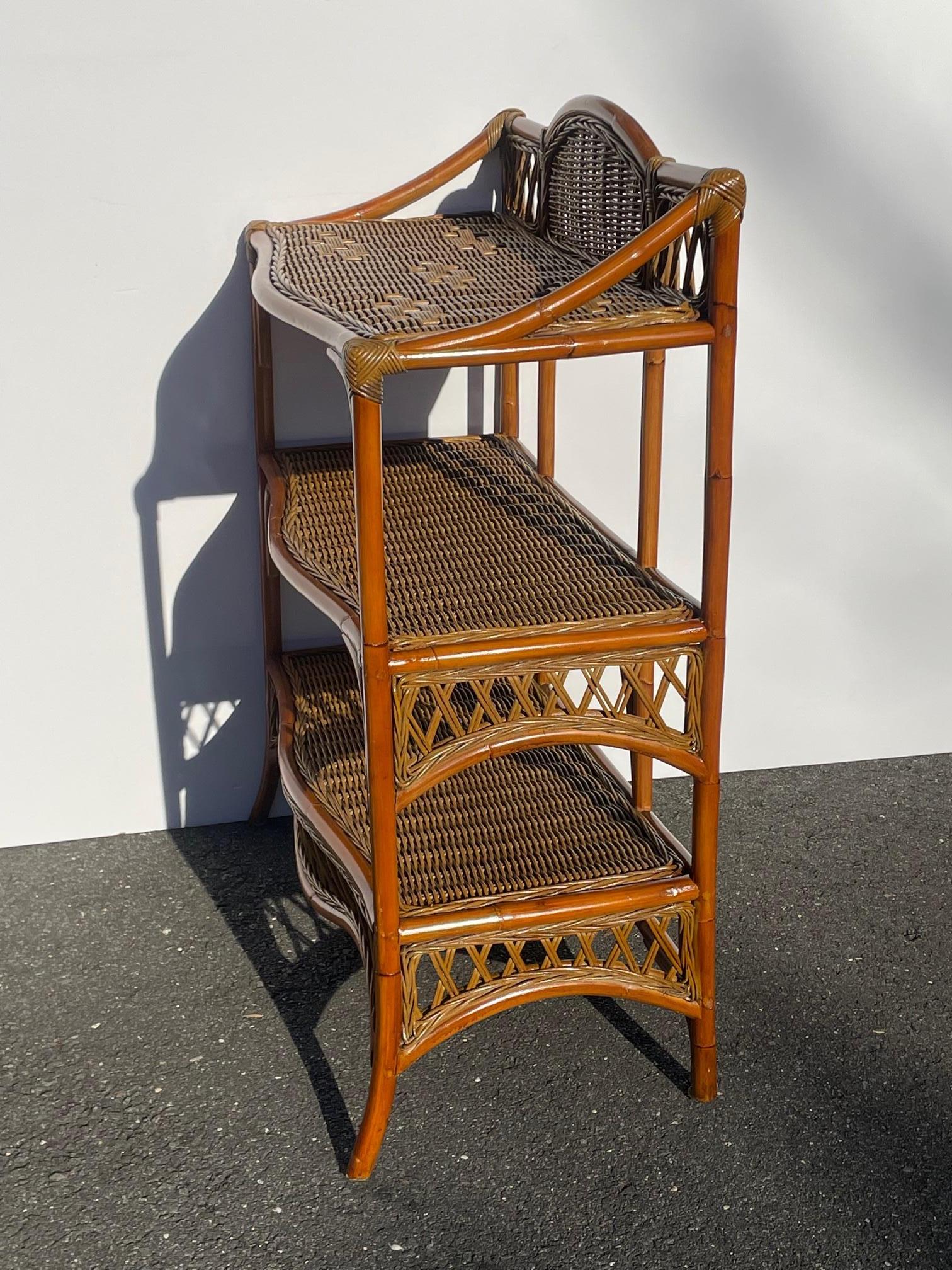 A great looking and functional 3 tier bamboo and rattan shelving unit having scalloped bottom and top with slightly splayed feet. Would be great in a bathroom with towels, etc. and also makes a stylish bookcase.