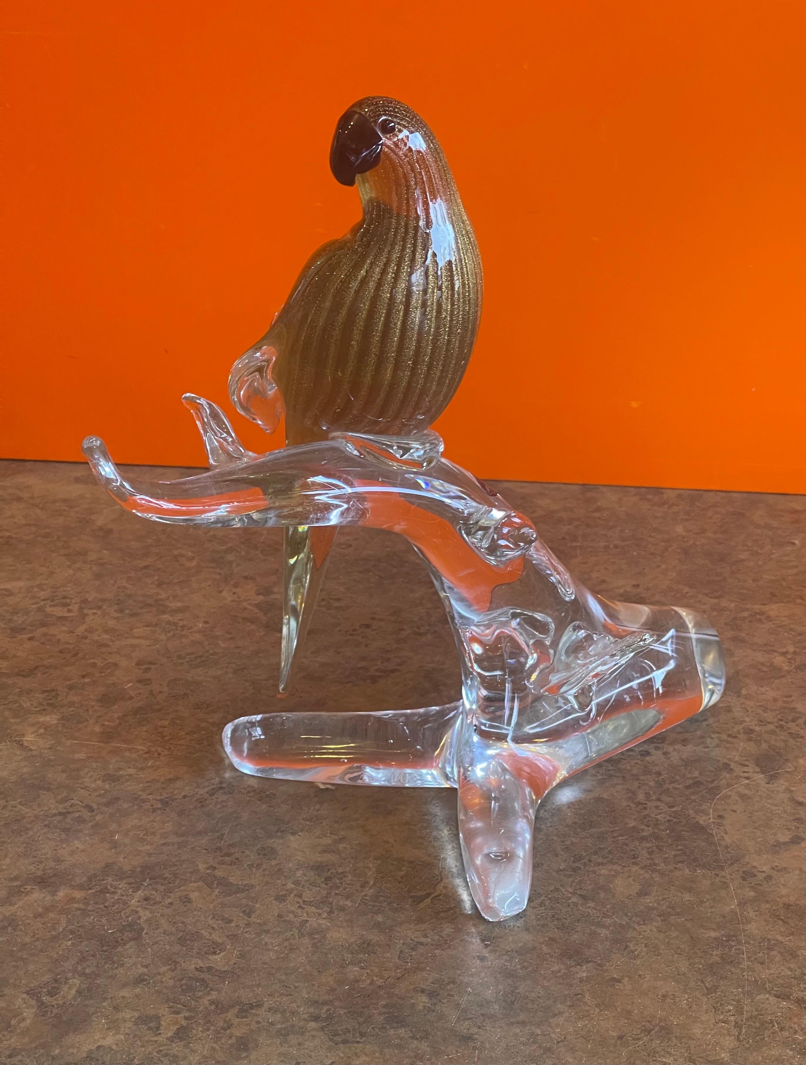 Stylish bird /parrot on branch art glass sculpture by Murano Glass, circa 1970s. The piece has a wonderful black and gold fleck color on a clear glass extended branch. The sculpture is in very good condition with no chips or cracks (some scratches