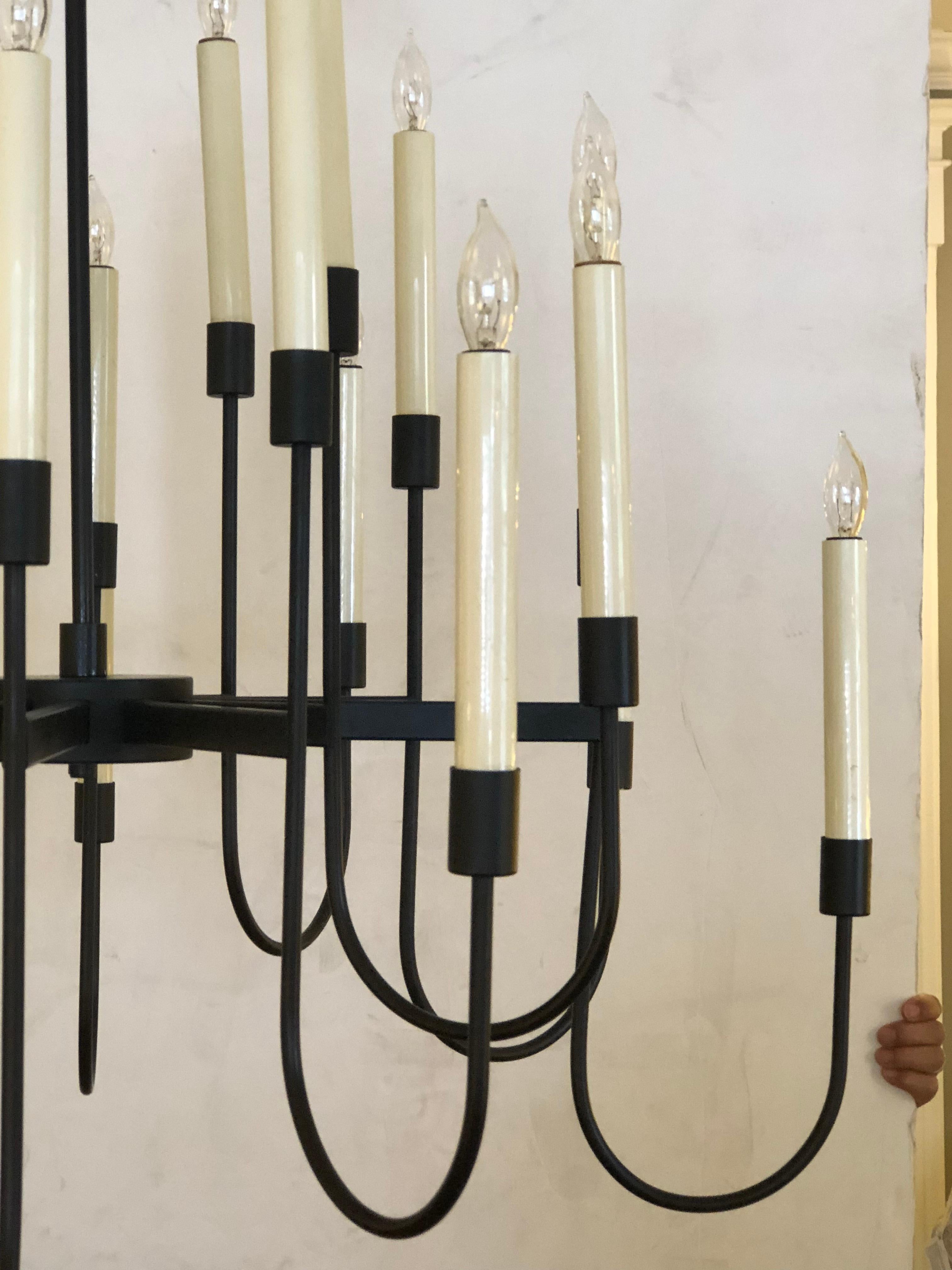 A stylish 1960s black enameled metal 12-arm candelabra style chandelier attributed to Tommi Parzinger; this large ever-so-chic fixture composed of 12 arms with two lights per arm often attributed to Tommi Parzinger and manufactured by Lightolier;