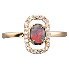 Elegante anello di fidanzamento con opale nero e diamante aureolato in oro giallo 18 carati