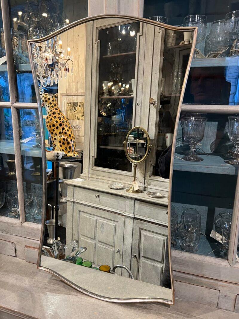 Superbe miroir mural en laiton du milieu du siècle, originaire d'Italie.

Jolie patine, et dans un design merveilleusement imaginatif.

D'un style similaire à celui des miroirs en laiton de Giò Ponti, avec des supports de suspension montés à