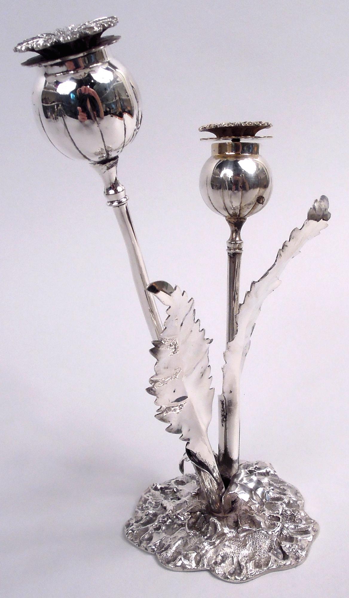 Élégantes salières et poivrières figuratives en argent sterling. Deux fleurs (l'une avec des traces dorées) placées dans un support. Chaque fleur a une tige curviligne, un bouton rond avec une couverture à deux feuilles filetées (feuille inférieure