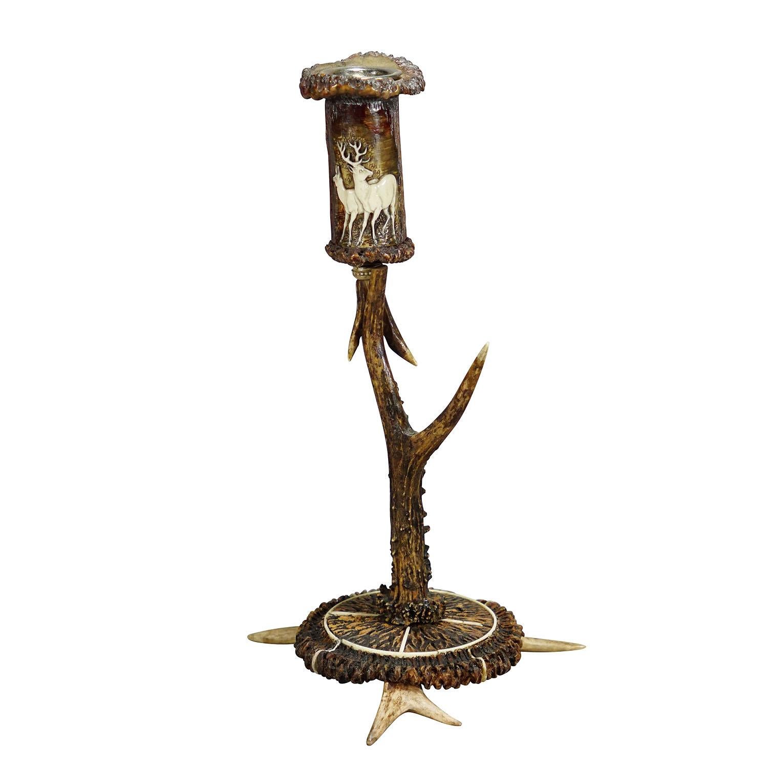Stylish cabin decor antler candle holder with deer carving, Germany ca. 1900

A fashionable rustic candle holder, made of antlers from the deer. The spout is made of turned antler pieces and features an elaborate deer carving. Base decorated with