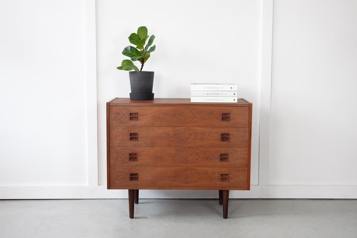 A beautiful chest of drawers with classically mid century inset handles, ideally sized for use as a TV stand or as a storage console in your living room or bedroom. The simple design is pleasing, characterised by clean lines and the natural wood of