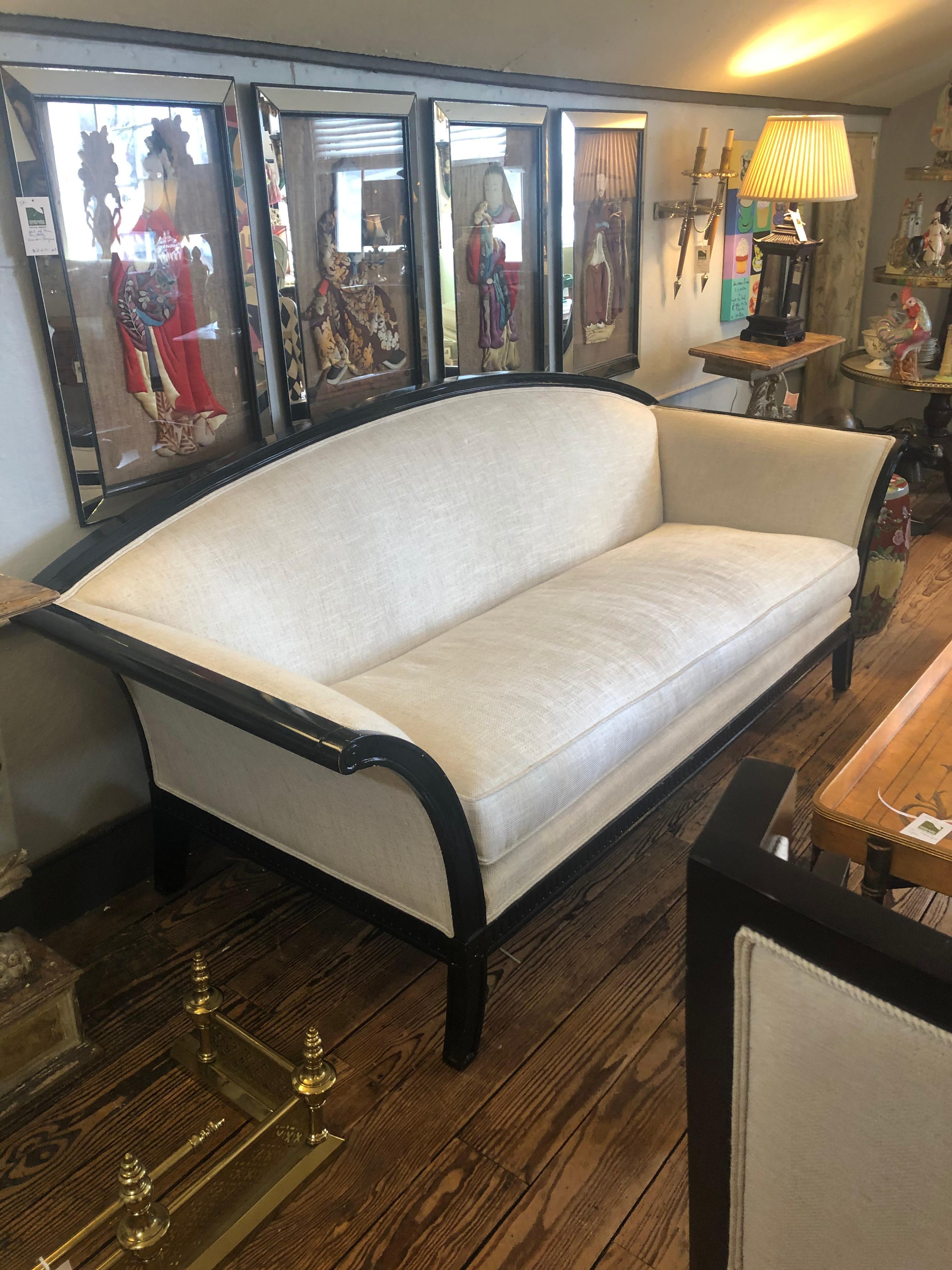 Very stylish sofa having black lacquer wood frame with curved back and splayed arms and legs, upholstered in a neutral nicely contrasting cream linen. Finished on the back so beautiful from every angle.